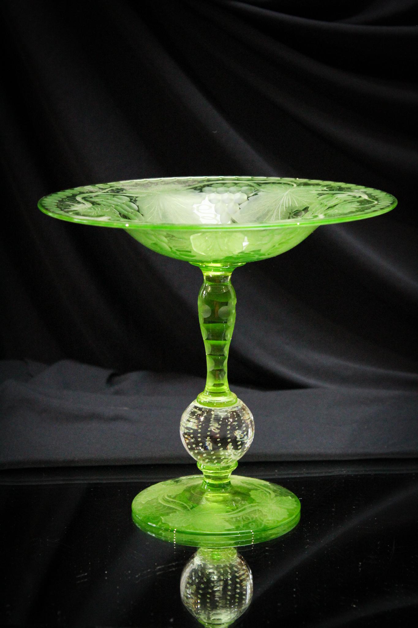 Pairpoint Green Glass with Grapes Compote: Pretty Pairpoint green glass with cut grapes and controlled bubble stem compote. Measures 7 1/2" tall.