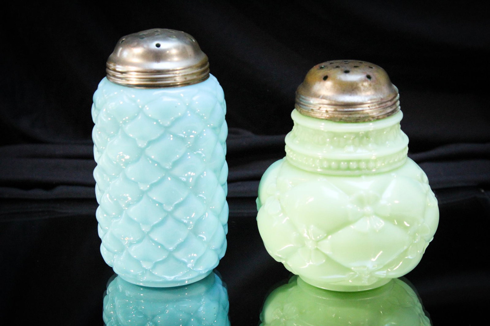 2 pc. Lot Victorian Glass Sugar Shakers Northwood & More: Super offering of two Victorian sugar shakers comprised of opaque examples of a Northwood quilted phlox pattern, and a consolidated cone example. Tallest measures 5 1/4" tall.