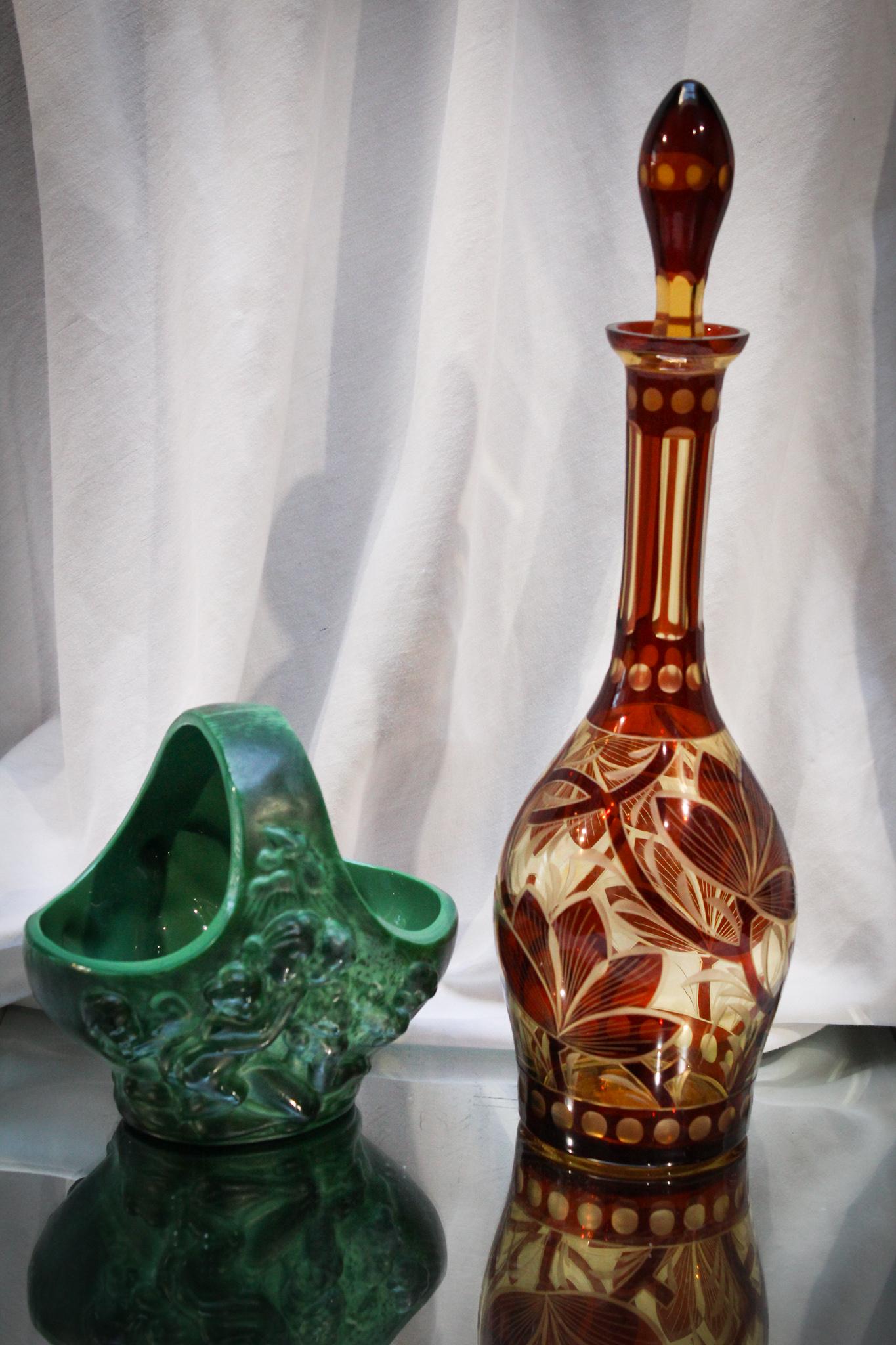2 pc. Lot Malachite Glass & Ruby Amber Stained Decanter: Superb offering of a Malachite glass basket and a ruby and amber decanter. Tallest measures 13 1/2" tall.