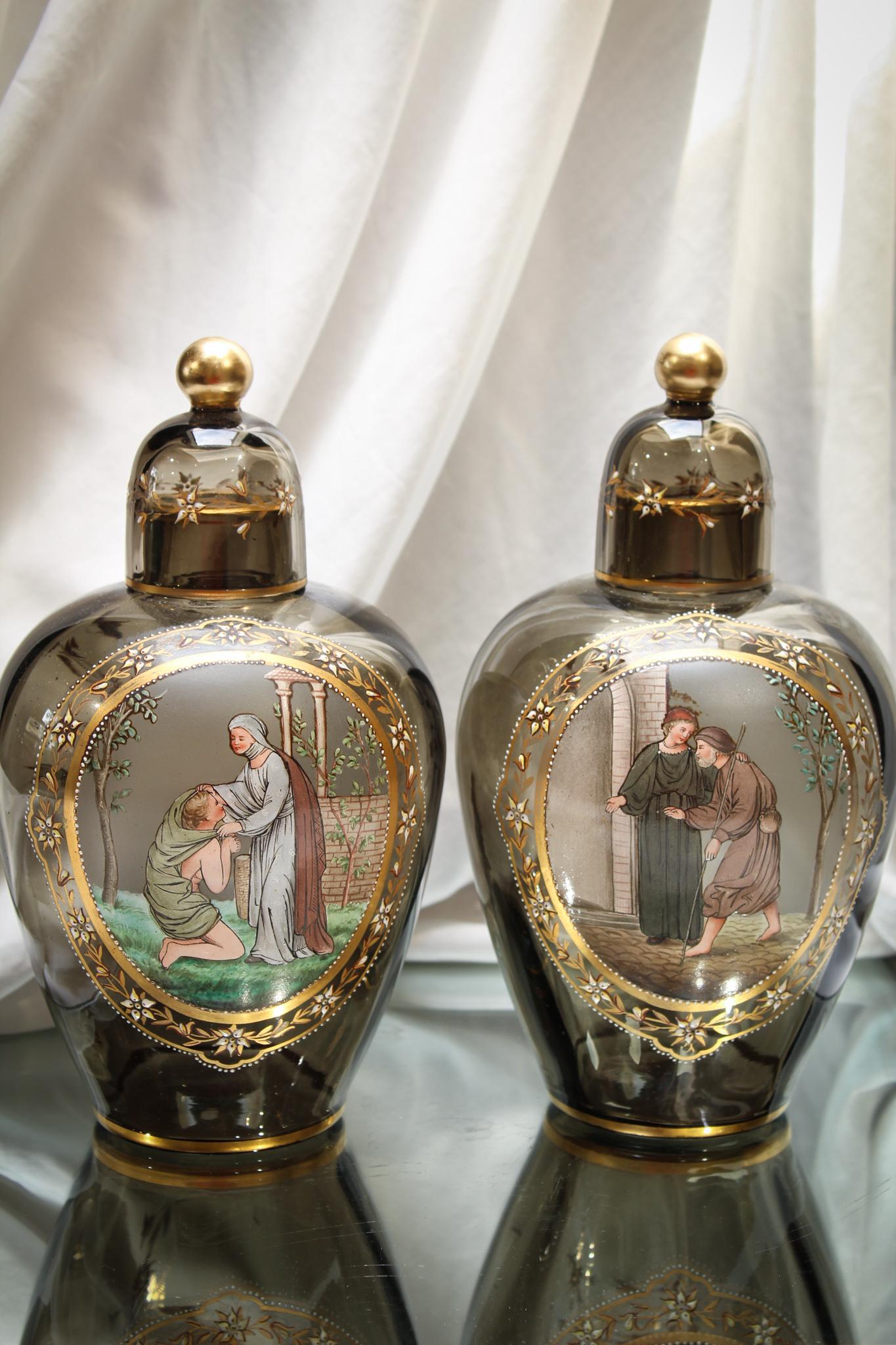 Pair Bohemian Smoke Gilt & Enameled Temple Jar Mantle Urns: How amazing are these two? An original pair of lovely Bohemian glass temple jars with gilt and enameled scenes. Each complete with it's original glass lid. Amazing these have survived all this time. M