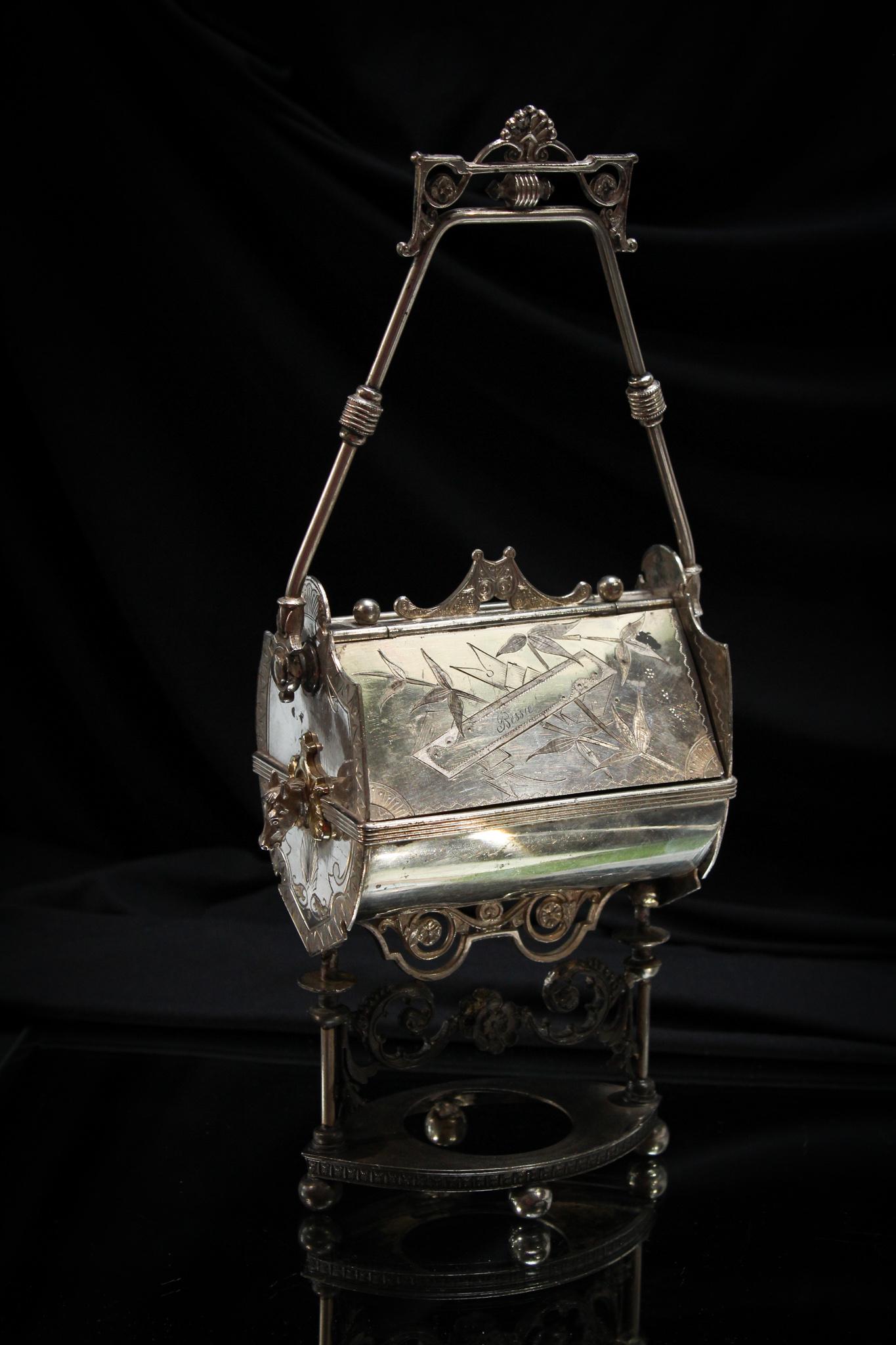 Victorian Meriden Silverplate Mechanical Jewel Casket w/ Horses: Very unusual signed Meriden silverplate Victorian mechanical jewel casket. Handle moves to reveal openings on either side. One each end there is a figural horse head. Engraved "Bessie". Measures 13" t