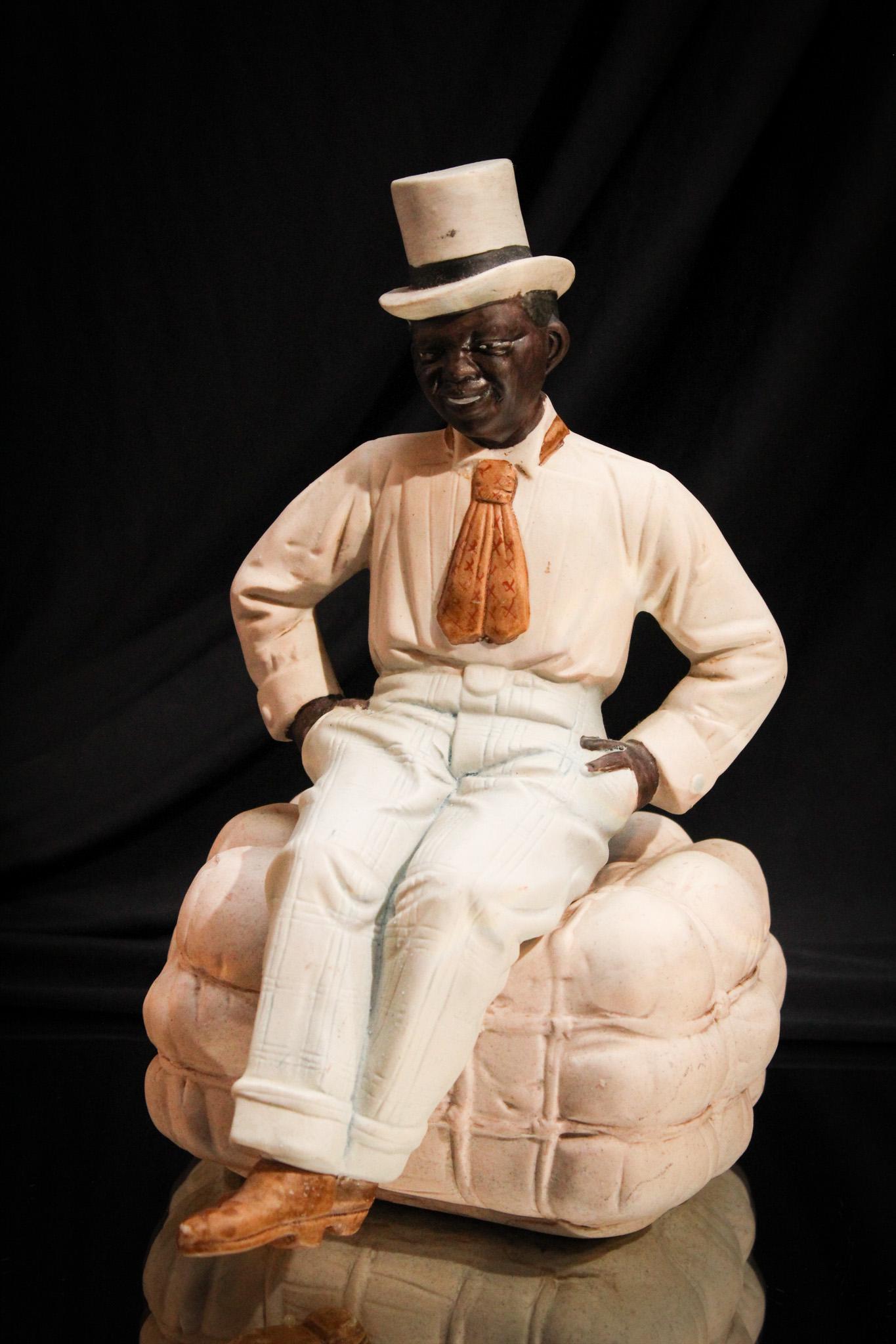 Americana Bisque Porcelain Figure on Bale: Charming American bisque figurine of man with top hat sitting on a bale of cotton. Great piece.