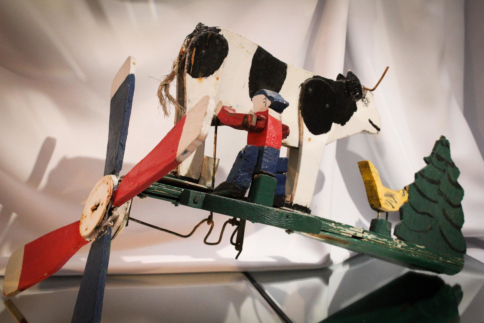 Folk Art Milking Man Cow & Yellow Bird Whirlygig: Folk Art Man milking a cow and bird whirlygig. Measures 16" by 15".