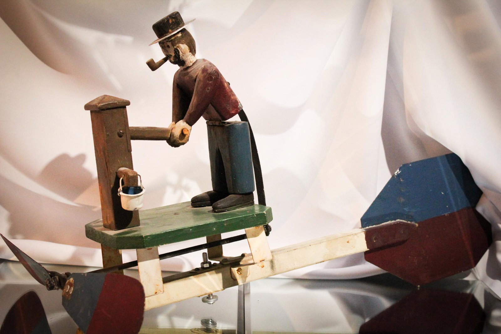 Man with a Pipe Pumping Folk Art Whirlygig: Man with a pipe pumping Folk Art whirlygig. Measures 25" by 13".