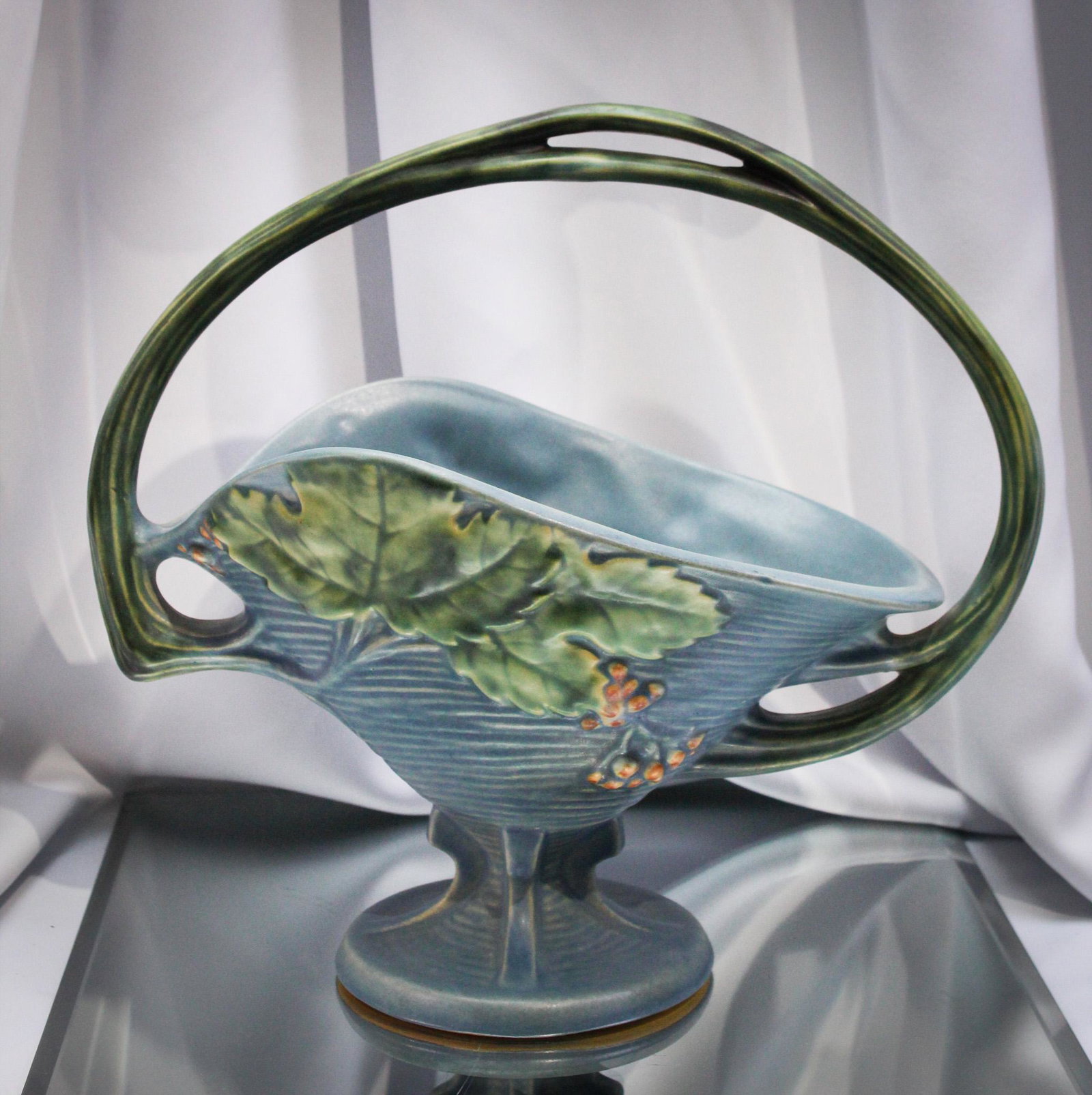 Roseville Pottery Bushberry Blue Basket: very nice example of the bushberry kind. Piece measures 12" tall.