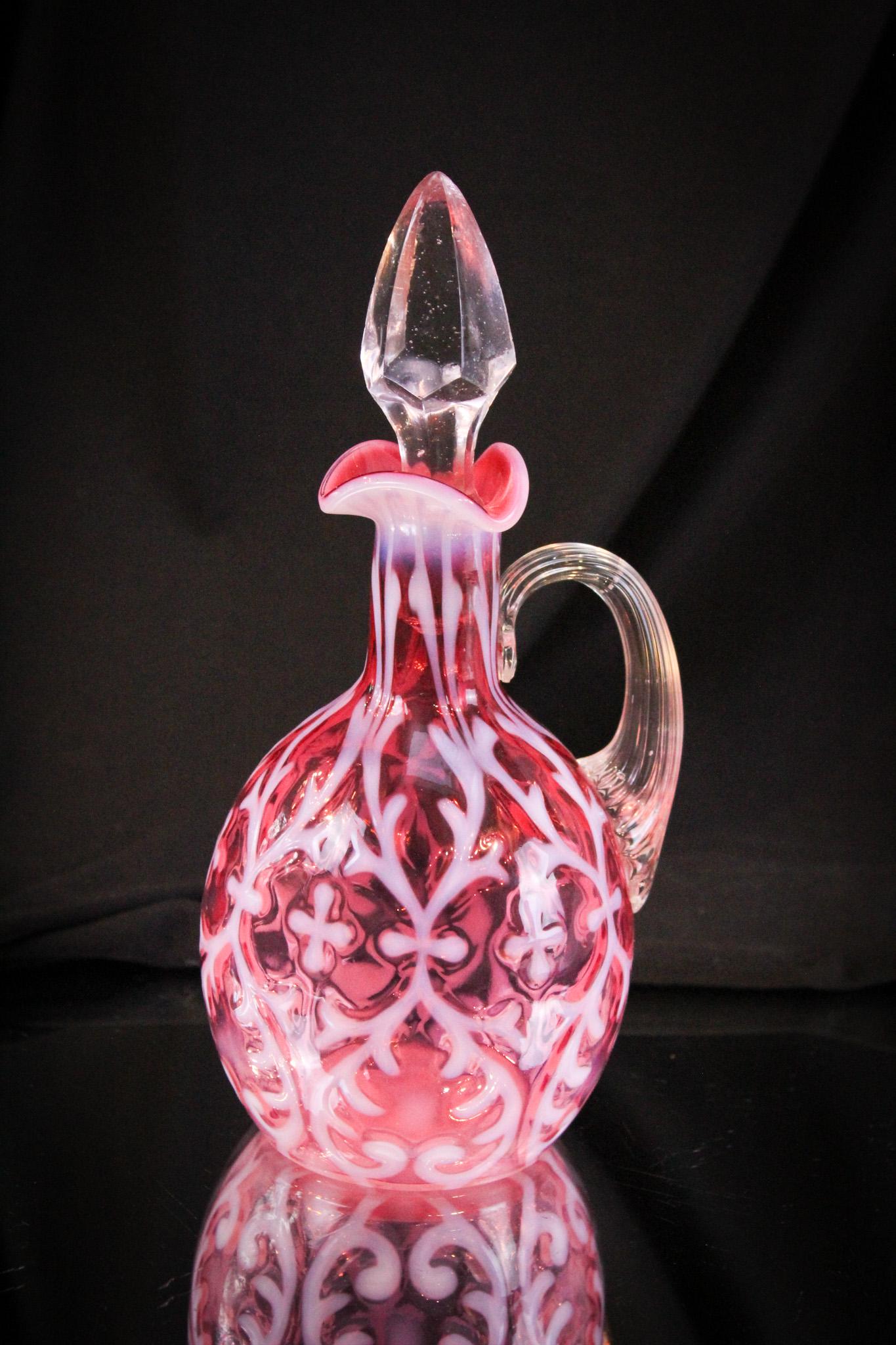 Cranberry Opalescent Victorian Glass Spanish Lace Cruet: Striking example of the Spanish Lace pattern in cranberry opalescence. Deep rich cranberry color and crisp strong white opalescence make up this honey. Measures 8" tall.