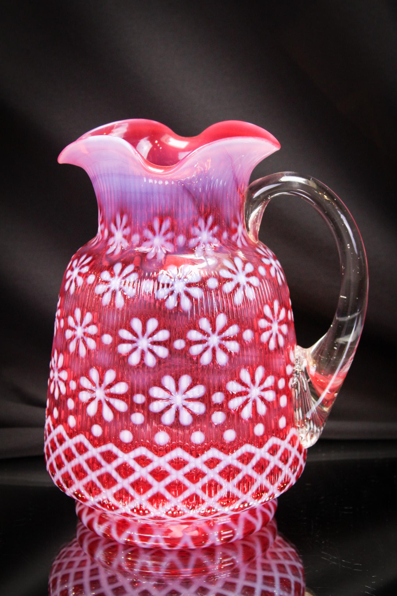 Northwood Cranberry Opalescent Christmas Snowflake Pitcher: Best of show here! That's right. You all remember Thelma Bob, our resident Honeychild here at Magnum Auctions, right? Thelma Bob loves this example. It reminds here of the Christmas times she spent wh