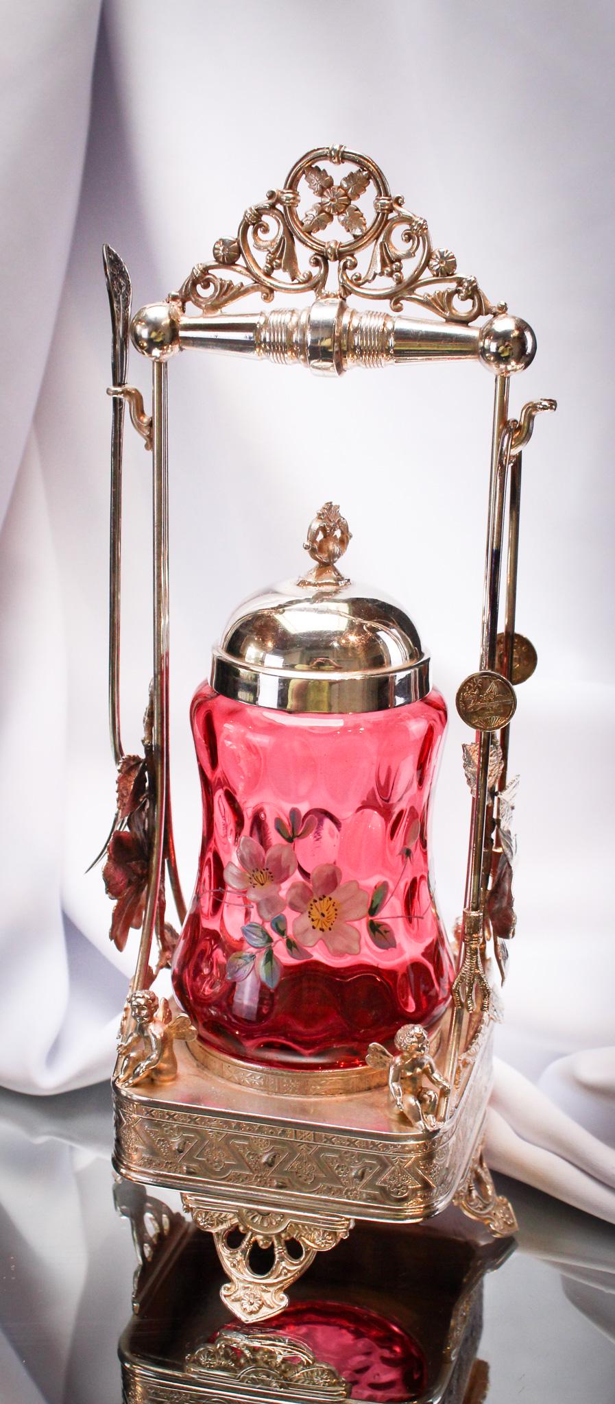 Simpson Hall Miller Victorian Cherubs & Cranberry Silverplate Enameled Pickle Castor: Not one, but four cherubs are seated at the base of this wonderful and high style Victorian Simpson Hall Miller signed pickle castor. Castor jar is rich cranberry enameled glass. Castor is complete wi