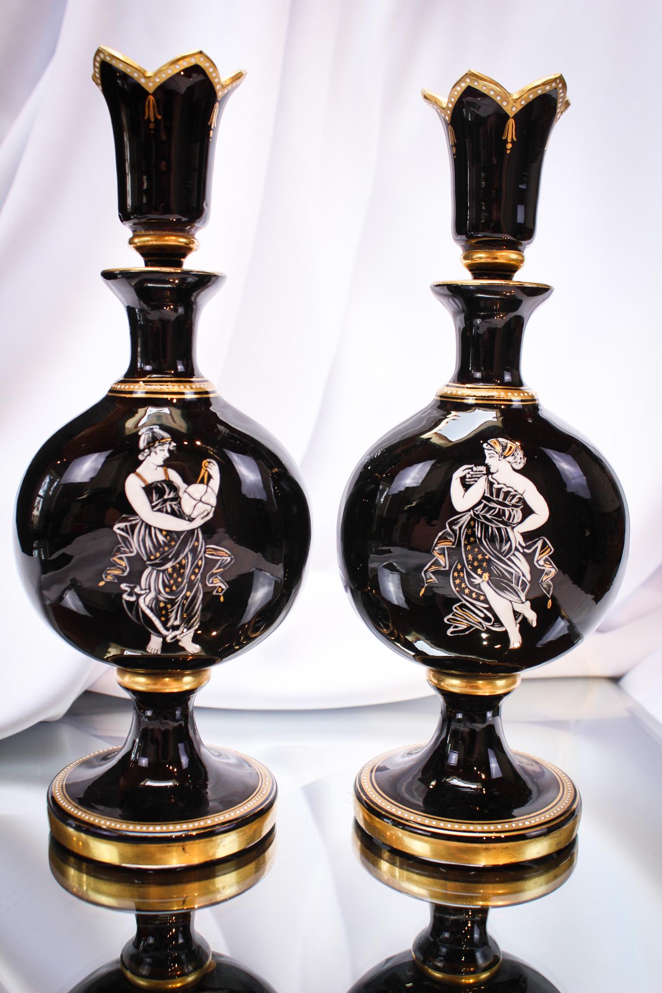 Pr. Victorian Black Enameled & Gilt Gass Cologne Bottles: Gorgeous pair of grecian women enameled cologne bottles of the gilded age. Each is complete with the original stopper. Nice pair and so seldom seen of this quality. Each measures 9" tall.