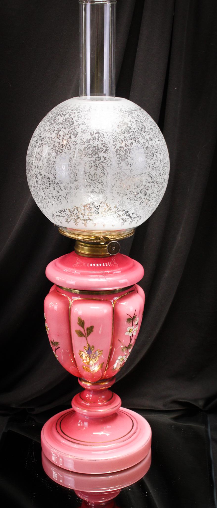 Victorian Enameled English Cased Glass Oil Parlor Lamp: Gorgeous deep raspberry cased pink glass is made even prettier by the addition of enameled and gilt decoration. Beautiful English lamp comes complete with etched shade. Measures 21" tall.