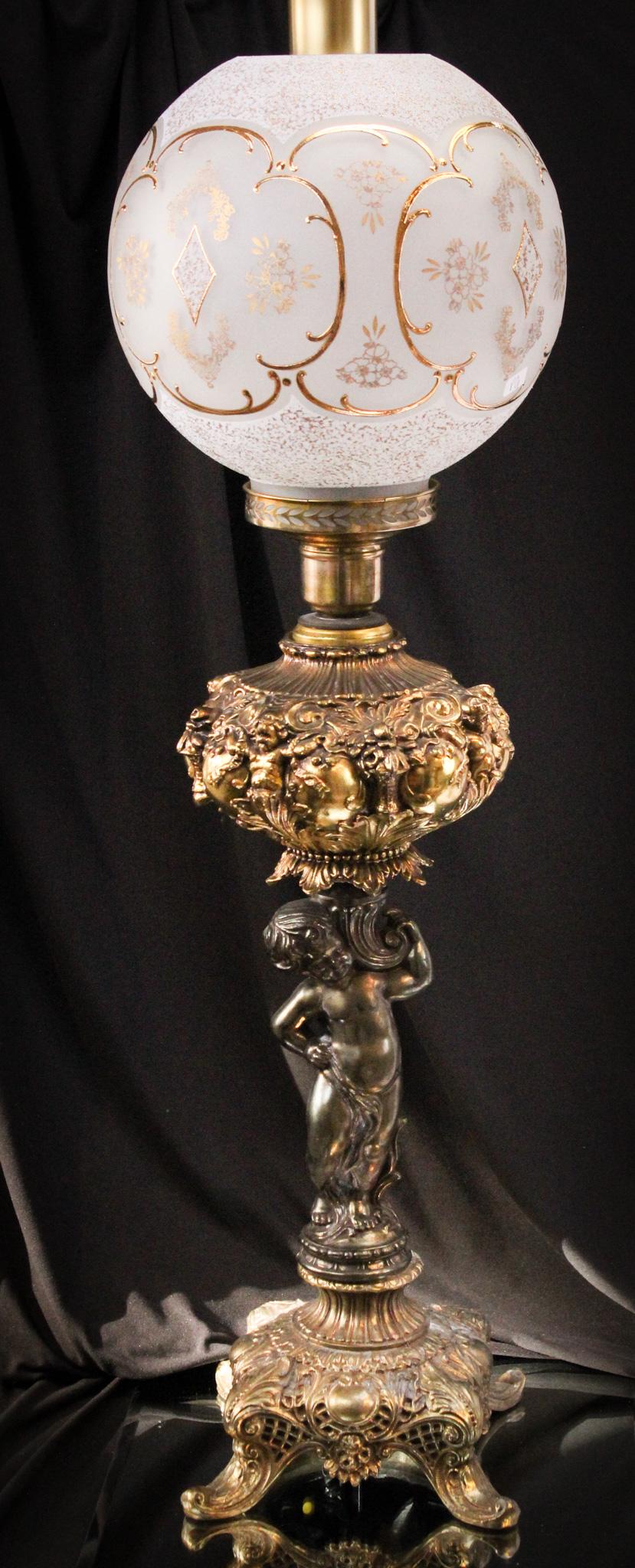 Gilt Cherub Hollywood Regency Banquet Lamp: Over-the-top wonderful. That's what we say about this gem. Base is adorned with cherub and shade is embellished with gilt decoration. The chimney is signed Queen. So appropriate. It measures a whoppin