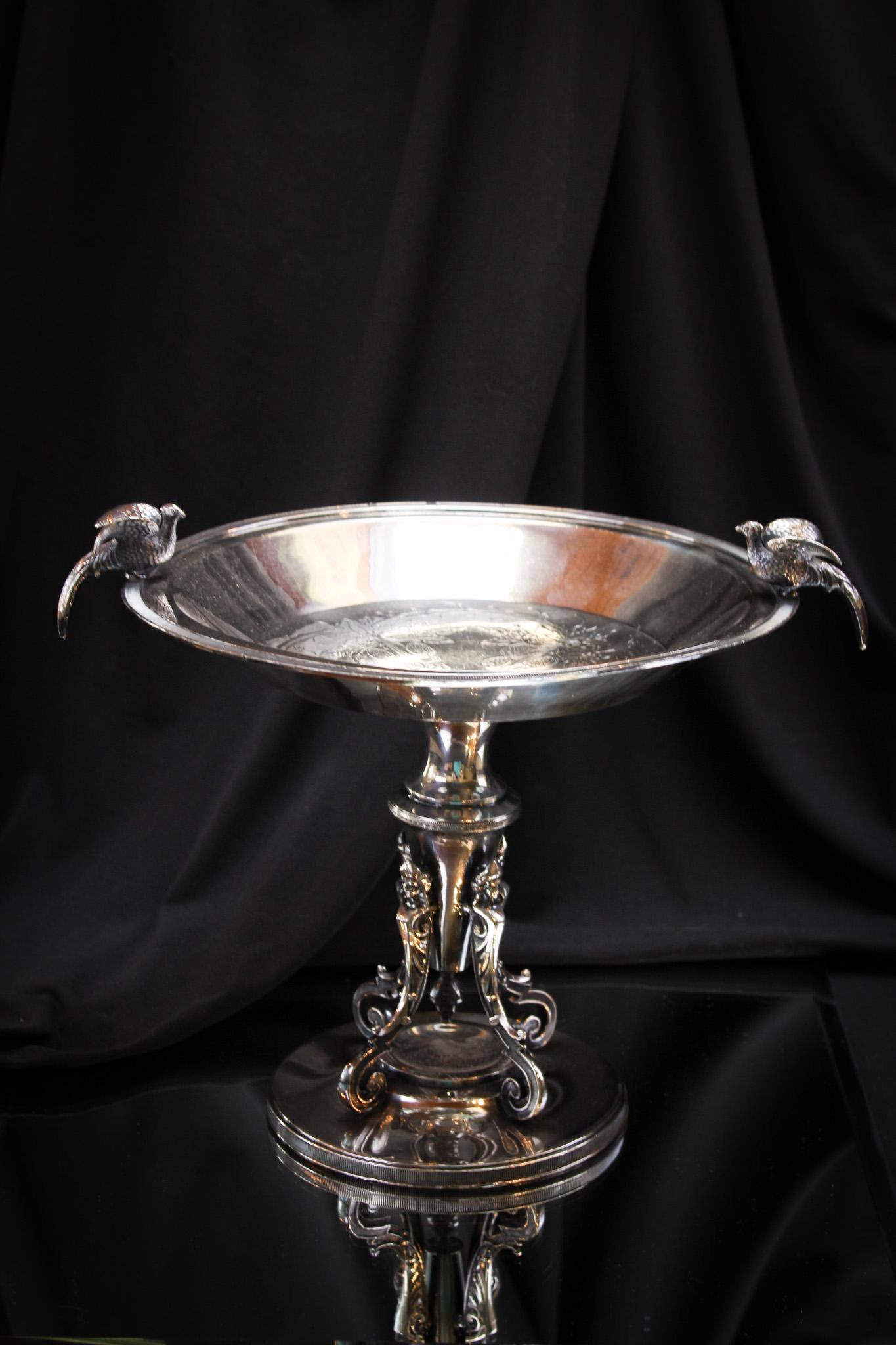 Victorian Meriden Silverplate Pedestal Tazza Centerpiece: Ornate Victorian silverplate signed Meriden pedestal compote tazza. Piece is highly ornate with engraved strawberries in the basin. Full figure birds on the top. Very nice. It stands 9" tall.