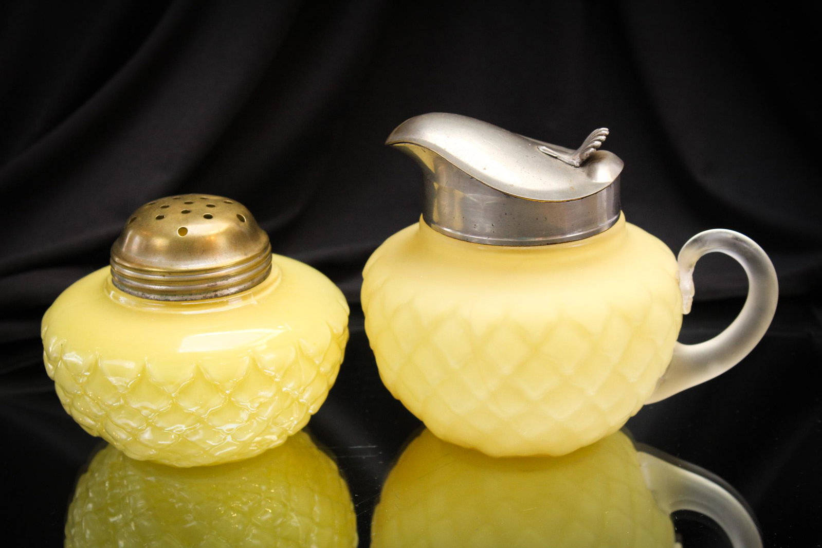 Fostoria Consolidated Yellow Cone Syrup Pitcher & Sugar Shaker: Two fine pieces of Fostoria Consolidated glass in the Cone pattern. These are in their classic yellow coloring. The syrup is satin finish. The sugar shaker is glossy. Tallest measures 4".