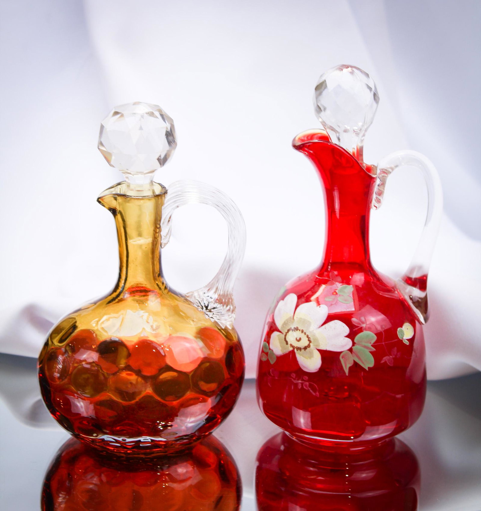 2 pc Lot Victorian Glass Cruets Pigeon Blood & Amberina: Two select offerings in the line of cruets, folks: One pigeon blood decorated Venecia, and one amberina inverted thumbprint example. Very nice! Tallest measures 7".