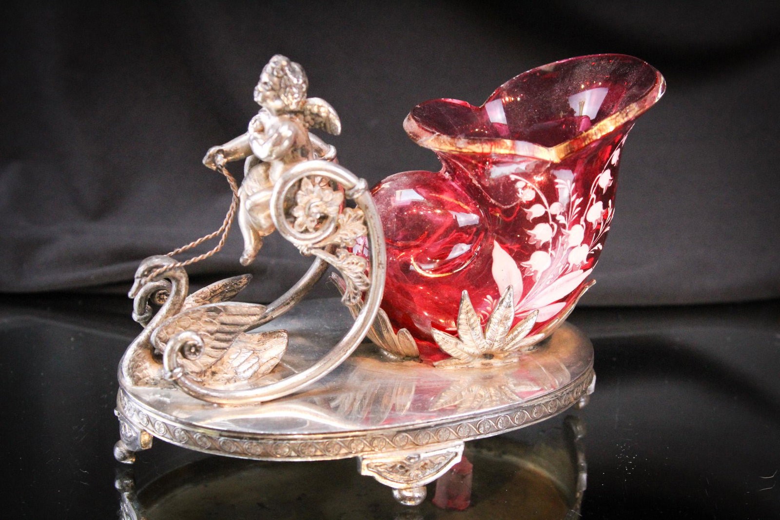 Aurora Figural Silverplate Victorian Cranberry Vase Whimsy: Gorgeous figural signed Aurora silverplate Victorian Whimsy of a cherub seated above a reined swan pulling a cranberry sleigh. Incredible piece. It measures 4 1/2" tall.