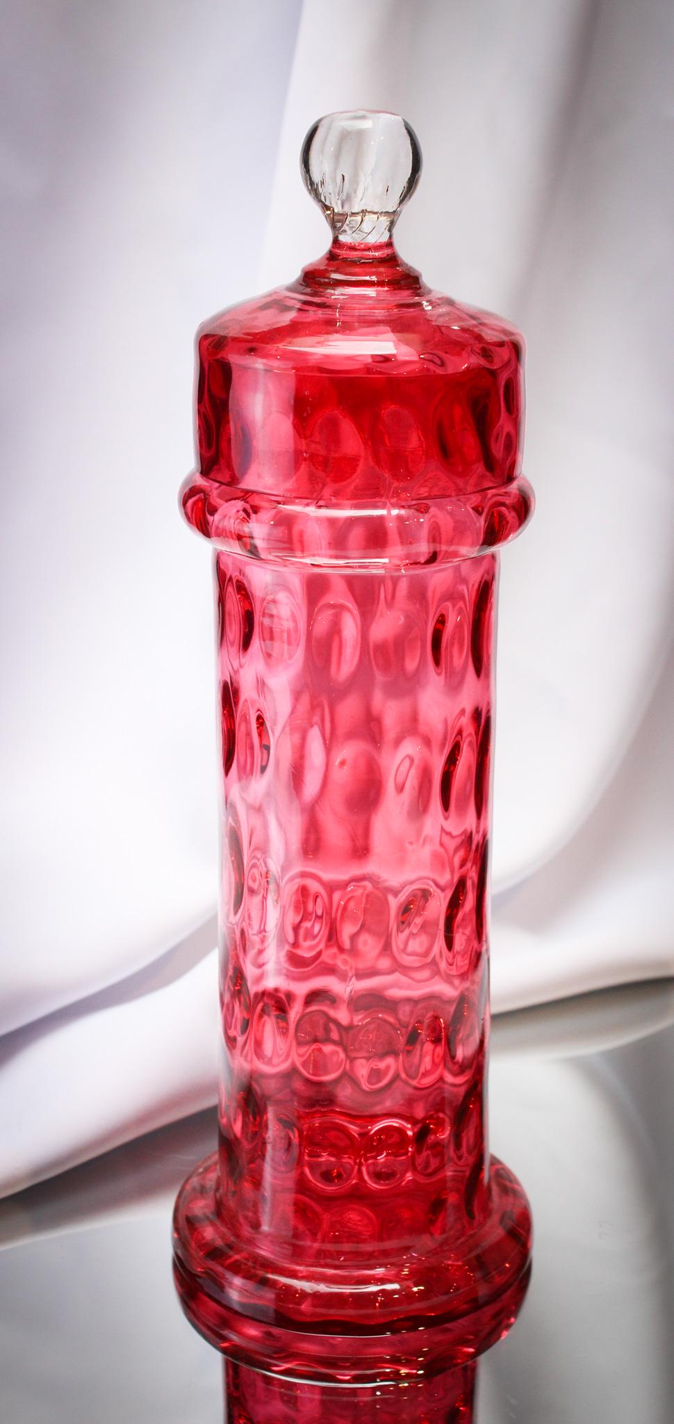 Very Rare Cranberry Inverted Thumbprint Straw Jar: Phenomenal all-original find here, folks. Victorian straw jar in cranberry Inverted Thumbprint with correct original lid. You never find these. Ever! It measures 13" tall.