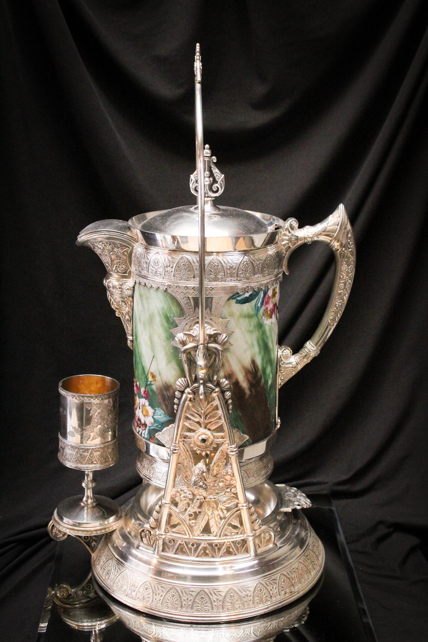 One of the Best Silverplate Victorian Glass Enamled Tiplers: This is without a doubt one of the most beautiful signed Simpson, Hall, Miller, and Co. silverplate tiplers we have seen. Complete with bristol glass hand painted glass liner featuring swallows, flora