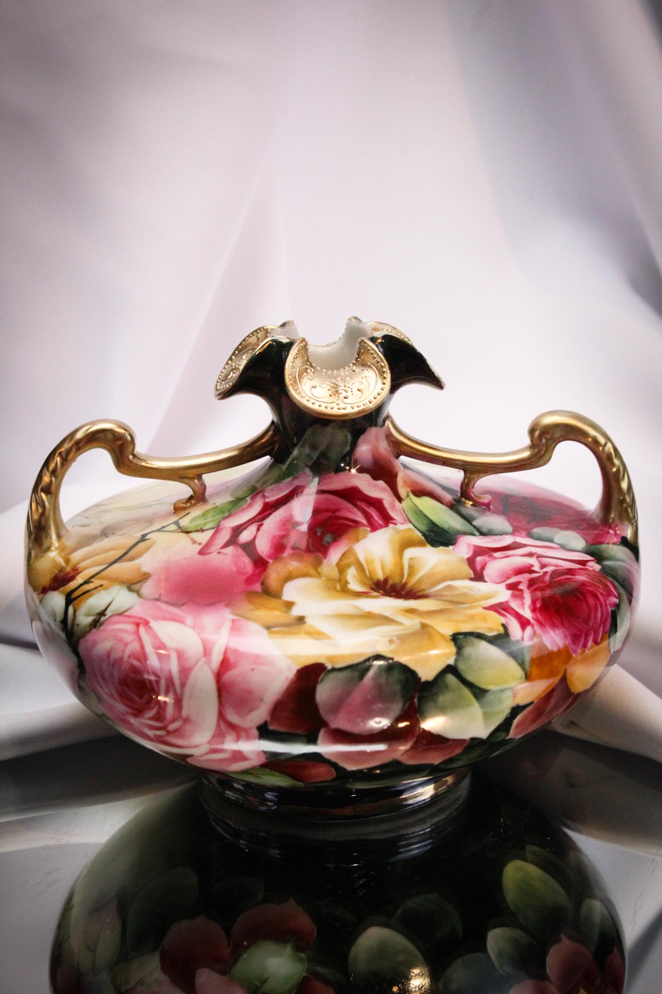 Nippon Roses Hand Painted Gilt Vase: Wonderful, over-the-top pretty in pink roses decorate this squat form vase with double handles and lots of gold trim. Piece is unsigned. Measures 6" by 8".