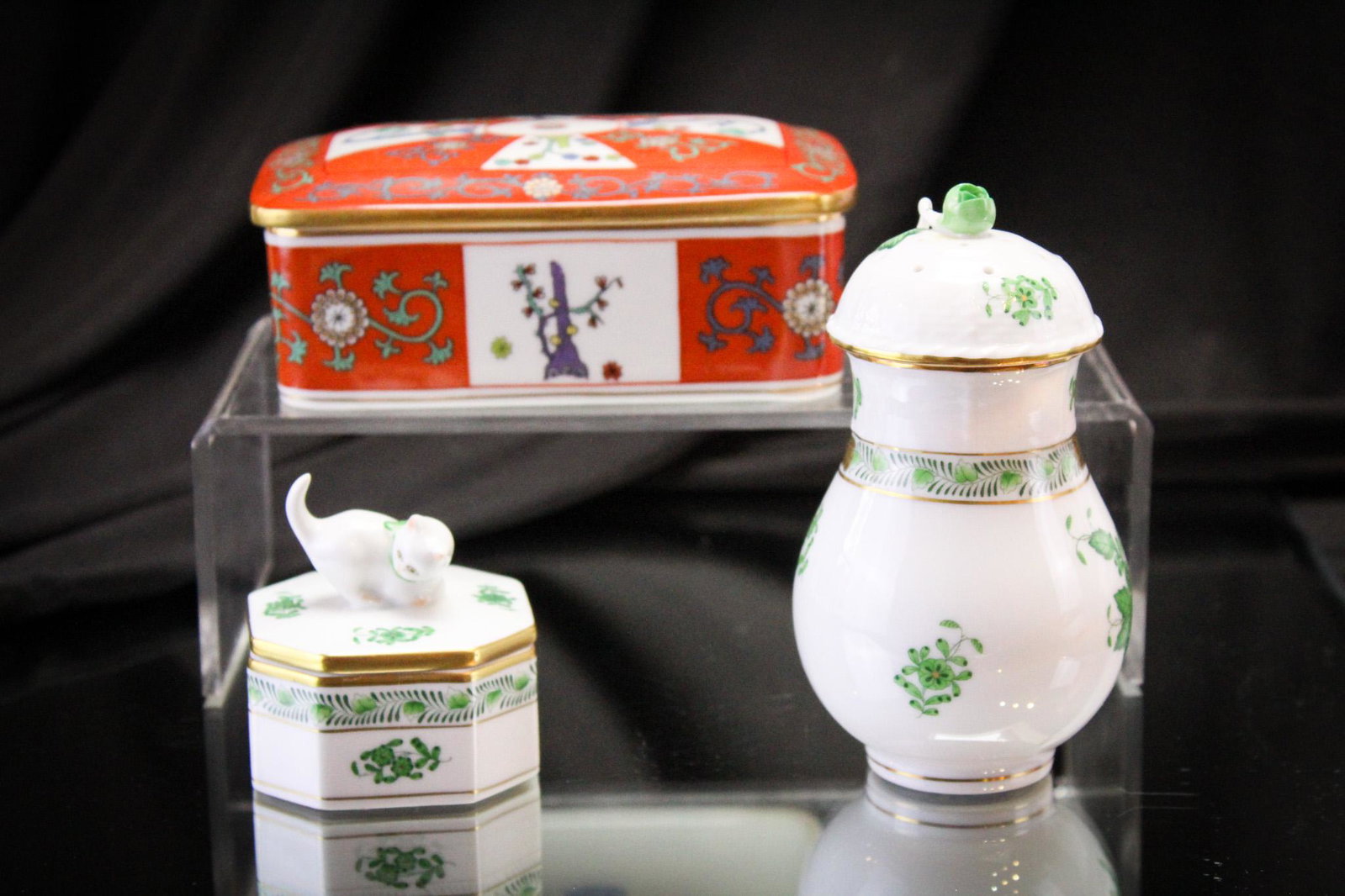 3 pc Lot Herend Porcelain Fineries: Select offering of three Herend porcelain signed pieces. Lot includes a green chinese bouquet cat trinket box, a green Chinese bouquet talc or sugar shaker, and a cigarette box. Largest measures 5".