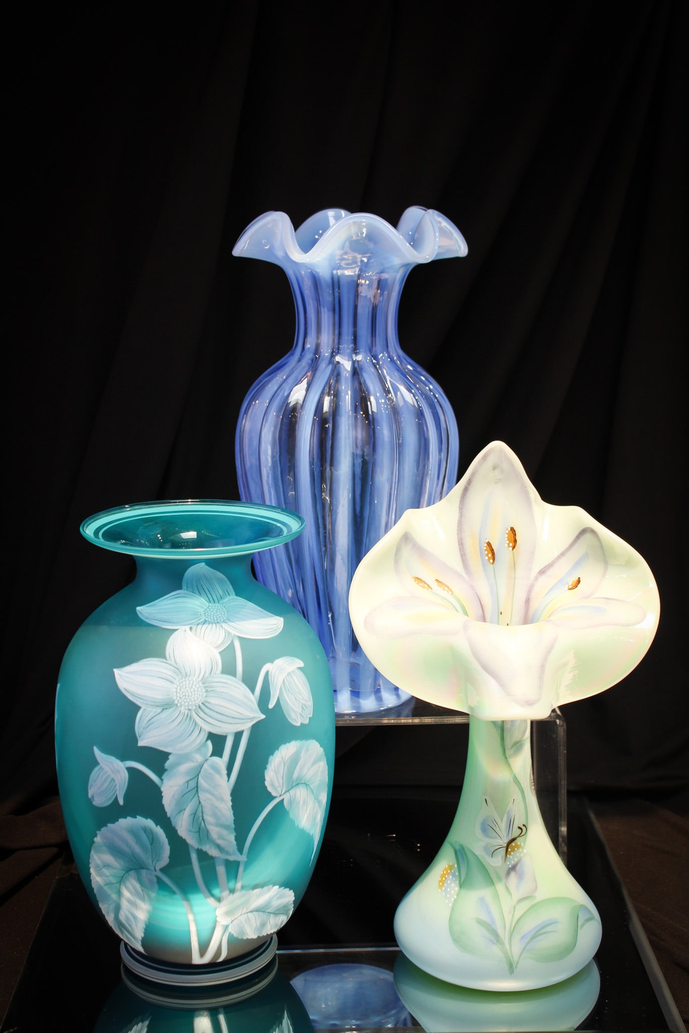 3 pc Lot Fenton Hand Painted Glass: Fenton artistry at it's best here folks! Three lovely examples comprised by a Jack in the Pulpit vase, a gallery originals blue vase, and completed by a blue opalescent rib optic vase.