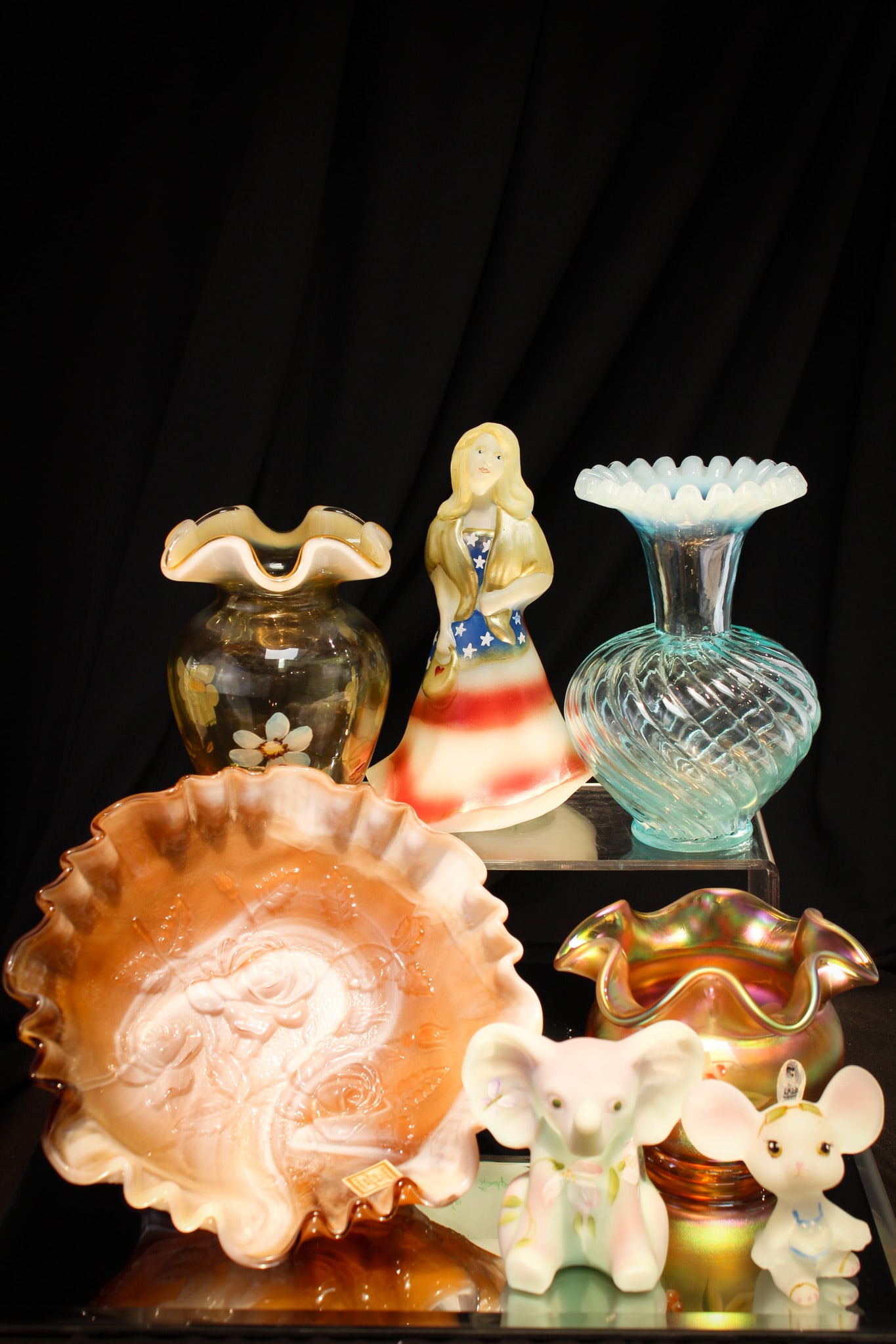 7 pc Lot Fenton Art Glass & More: Fine seven piece lot of art glass comprised of Fenton & Imperial. Two figurines, one patriotic girl, three vases, and an Imperial slag bowl.