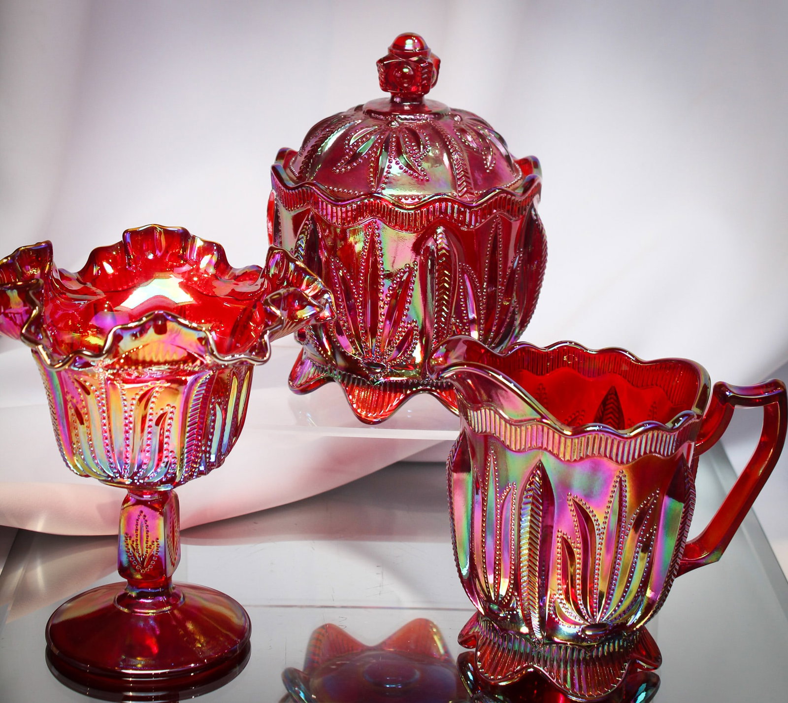 3 pc lot Fenton Levay Red Carnival Glass: Great pieces combined to make one phenomenal lot of Fenton Levay red carnival "Cactus" pattern. Lot is comprised of a compote, creamer, and sugar.