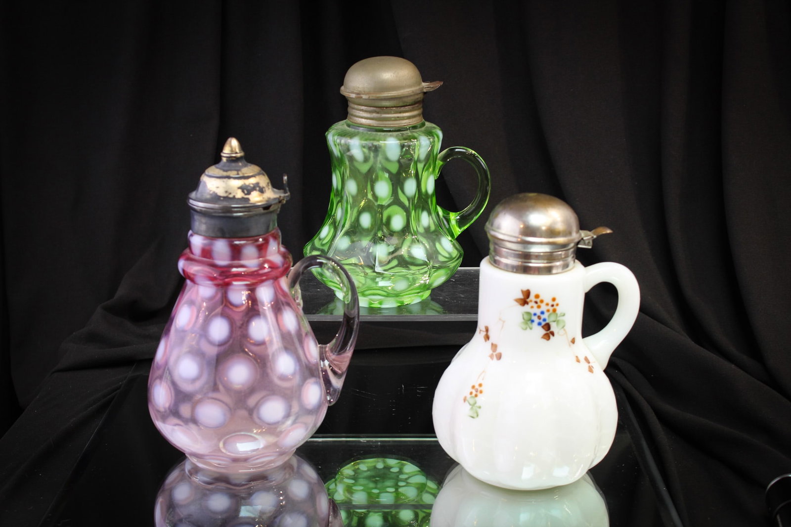 3 pc Lot Victorian Opalescent Glass Syrup Pitchers: Nice offering of three Victorian glass syrup pitchers. One in rubina opal coinspot. One in green opal coinspot. The third in decorated opal glass.