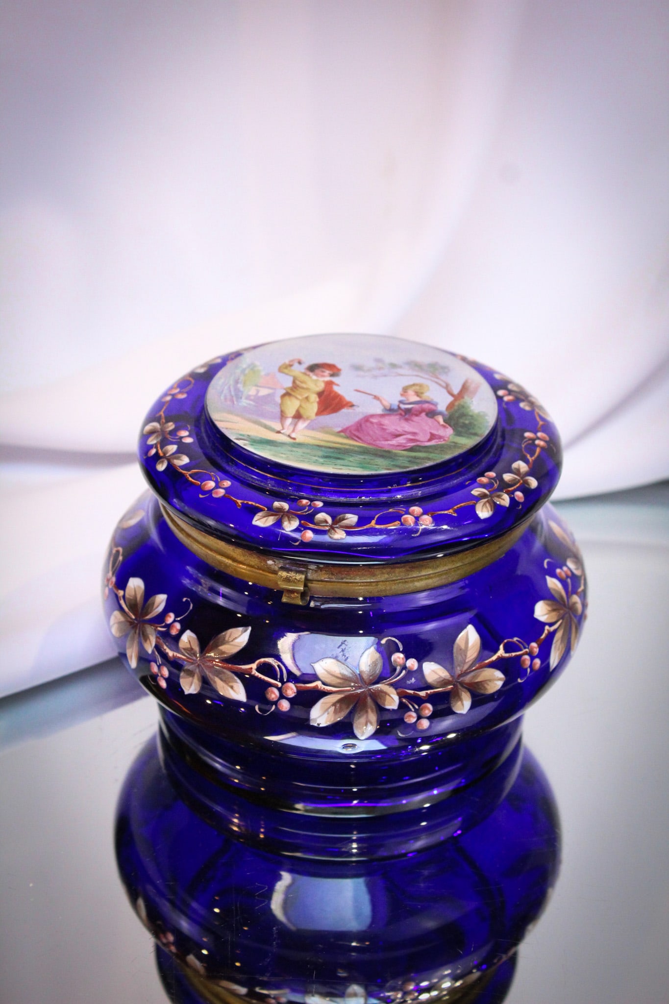 Victorian Cobalt Glass Enameled Courting Scene Dresser Box: Wonderful Victorian cobalt glass enameled decorated dresser box. Enameling depicts a courting scene. Very pretty and tough to find one as nice as this one! Measures 4" by 5 1/2".