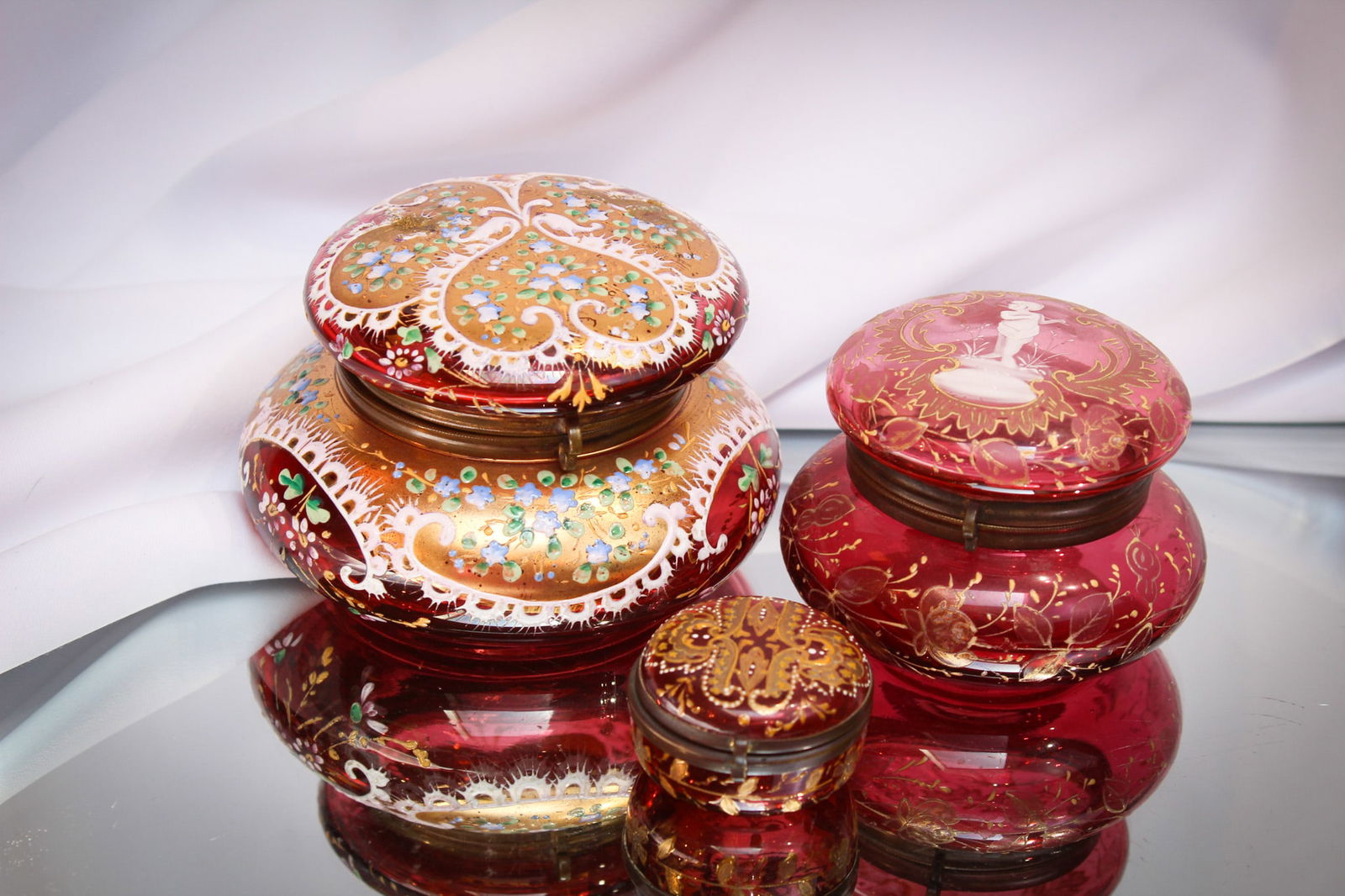 3 pc Lot Victorian Cranberry Glass Gilt Enameled Boxes: Nice array of some Victorian pleasure in cranberry glass. Three superb pieces, one as nice as the next. All unique in form, decoration and size, these are nice! Take a look. Largest measures 3" by 4 1