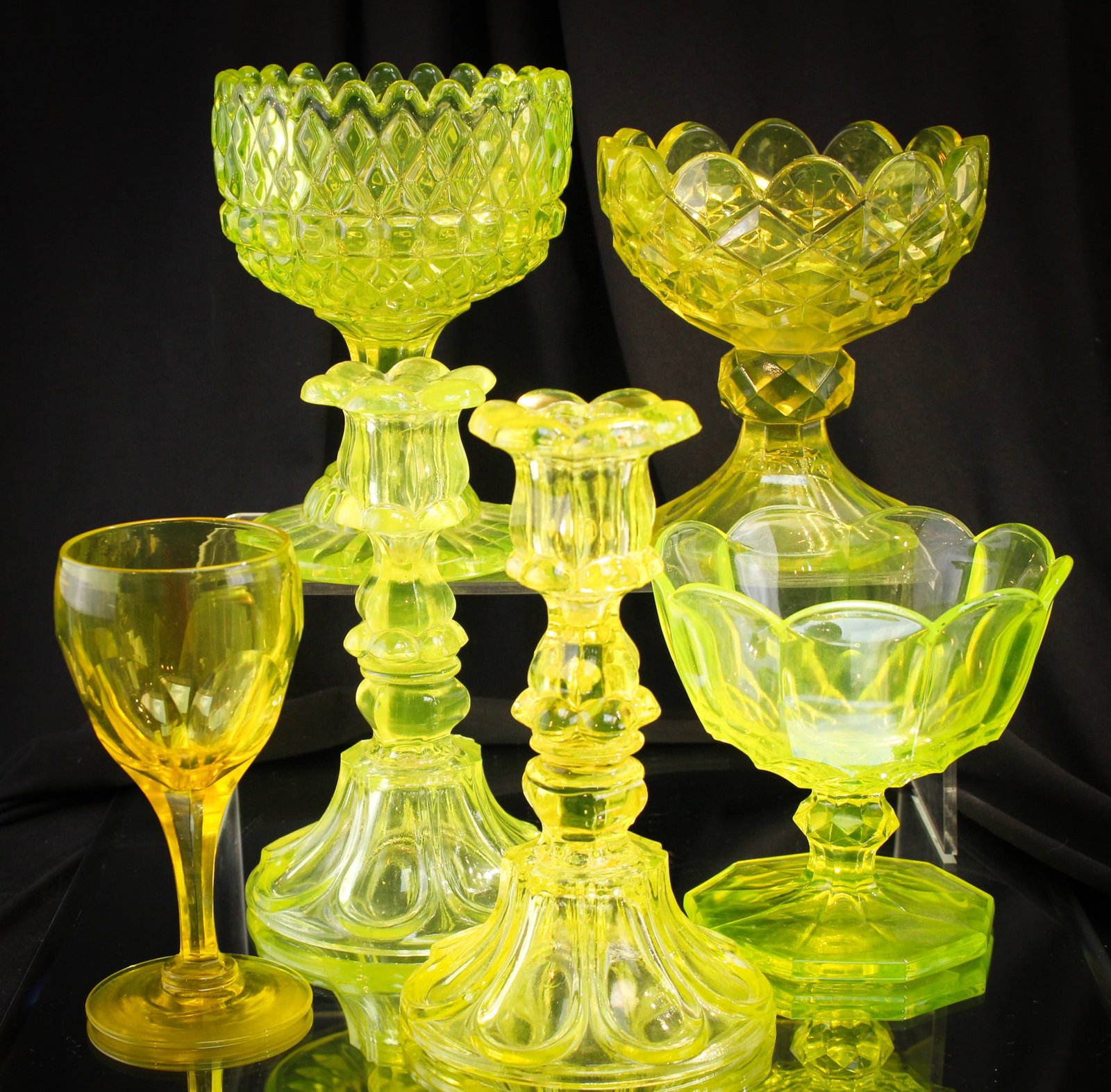 6 pc Lot Victorian Vaseline Flint Glass & More: Generous six piece lot of Victorian Vaseline flint glass. Lot is comprised of a pair of Sandwich "Petal & Loop" pattern candlesticks, two english open sugars, a domestic open sugar, and a wine stem. S