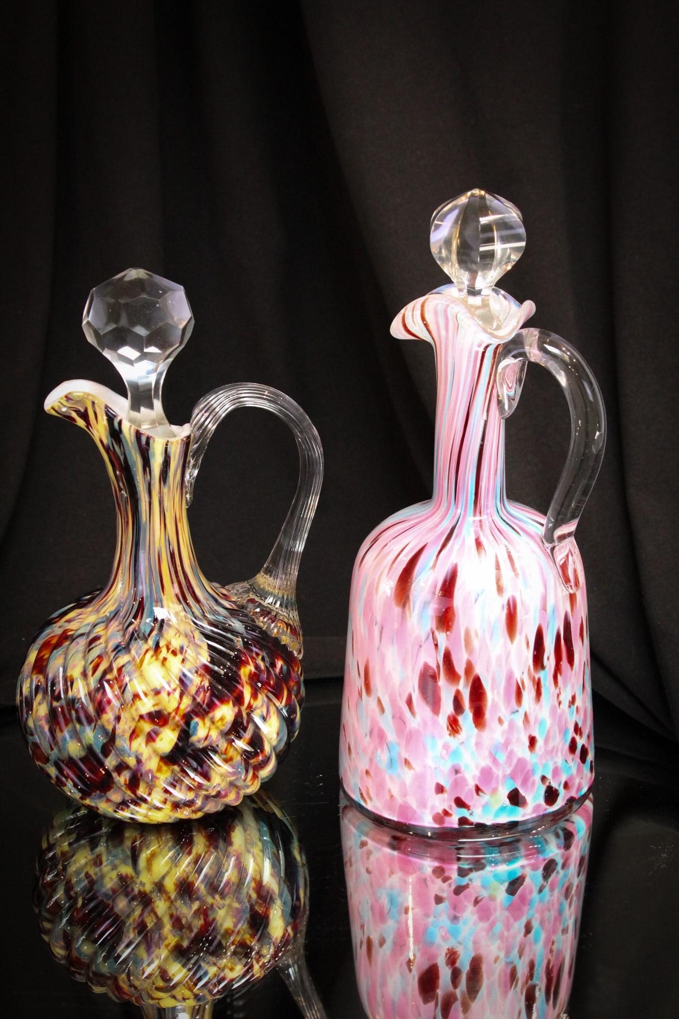 2 pc Lot Victorian Splatter Glass Cruets: Two fine splatter glass cruets paired together in this lot. One in multi colored spatter. The other in pink and blue splatter.