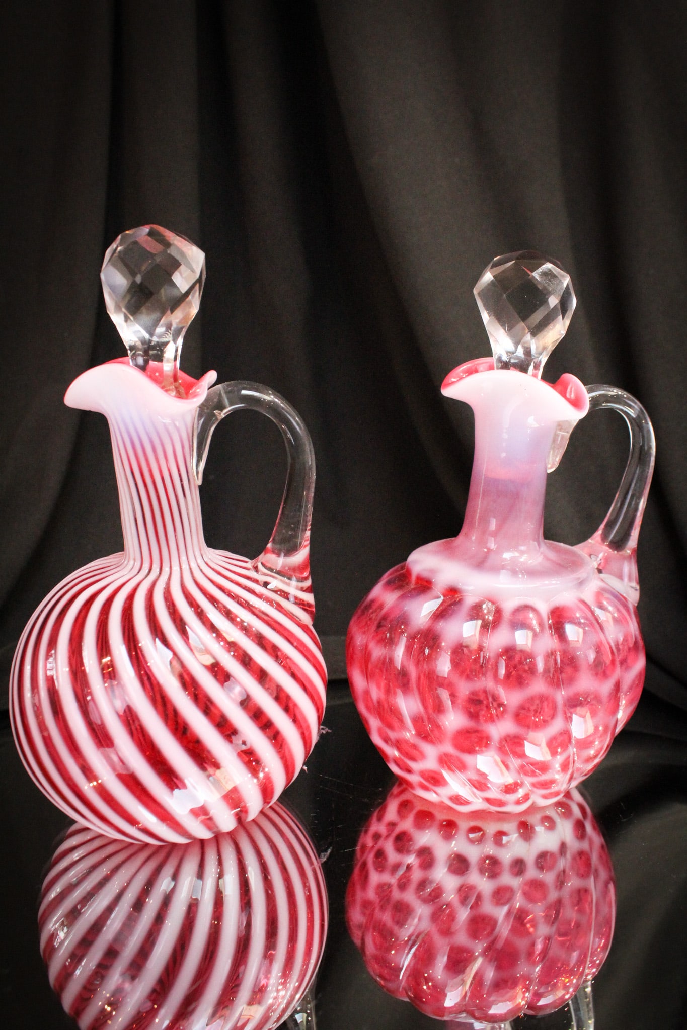 2 pc Lot Victorian Hobb's Cranberry Opalescent Cruets: Select offering of two Victorian cruets by Hobb's. One in the "Windows Swirled" pattern. One in the "Swirl" pattern.