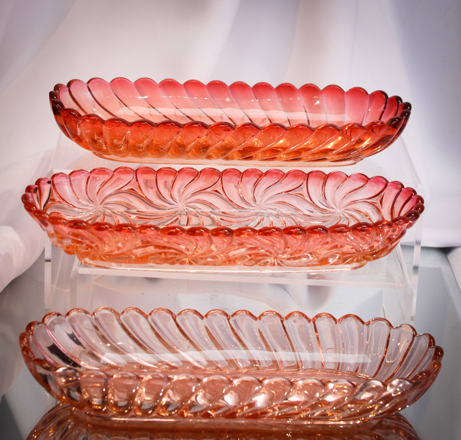 3 pc Baccarat Rose Tiente France Glass Relishes: Nice assembly of three Baccarat Rose Tiente colored oblong relish dishes. Each measuring about 9 1/2" long by 1 1/2" tall. The pin wheel swirl example along with the darker swirl example are clearly s