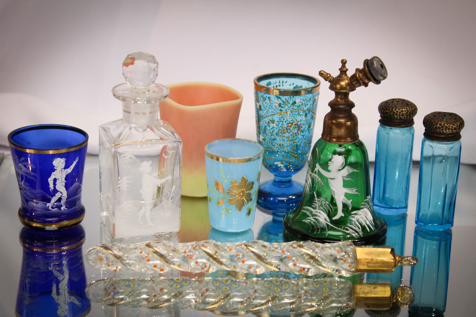 9 pc Lot Victorian Glass Enameled Burmese Mary Gregory Opaline & More: Wonderful nine piece lot of Victorian fineries. Lot is comprised of enameled pieces including a blue opaline cup, a Mary Gregory cup and perfume and atomizer. An enameled lachrymatory bottle and so mu
