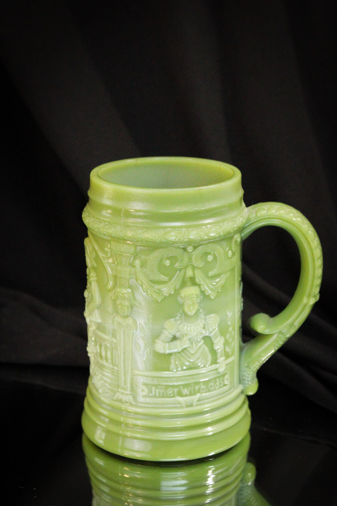 Greentown Nile Green Glass Drinking Scene Mug: Select offering of a Greentown Drinking Scene Mug in nile green glass.
