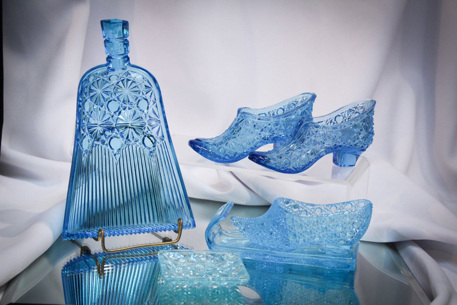 5 pc Lot Victorian Novelty Glass & More: Select offering of five great Victorian glass novelty & more items sure to please. Lot is comprised of a Daisy & Button dust pan, 2 shoes, a butter pat, and a slipper on a sleigh.