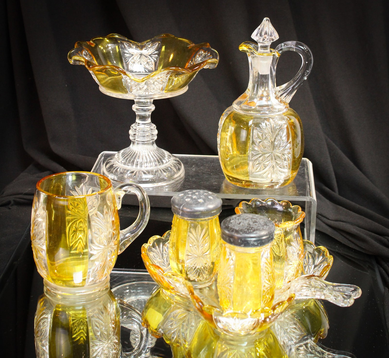 7 pc Lot Riverside Brillaint Amber Stained Victorian Glass: Select offering of seven pieces of Riverside glass "Brilliant" pattern. Lot is comprised of jelly compote, pair of shakers, toothpick, tray, cruet, and mug. Go find them!