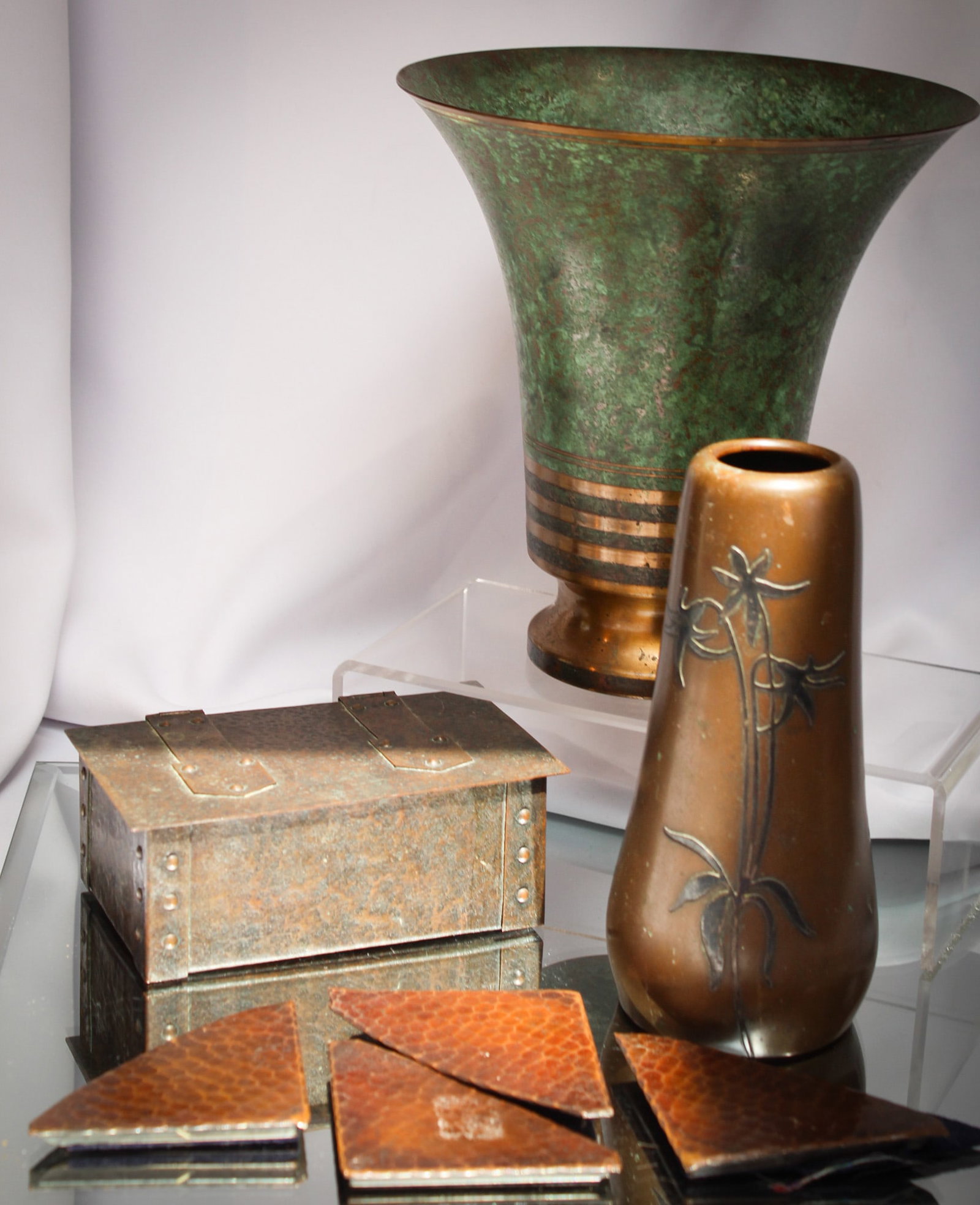 7 pc Lot Arts & Crafts Roycroft Heintz Carl Sorensen & More: Bounty of a lot here in the arts and crafts genre. This lot is comprised of a "Carl Sorensen" vase, a "Heintz" sterling over copper vase, "Roycroft" desk pad corners, strap hinged copper box and more.