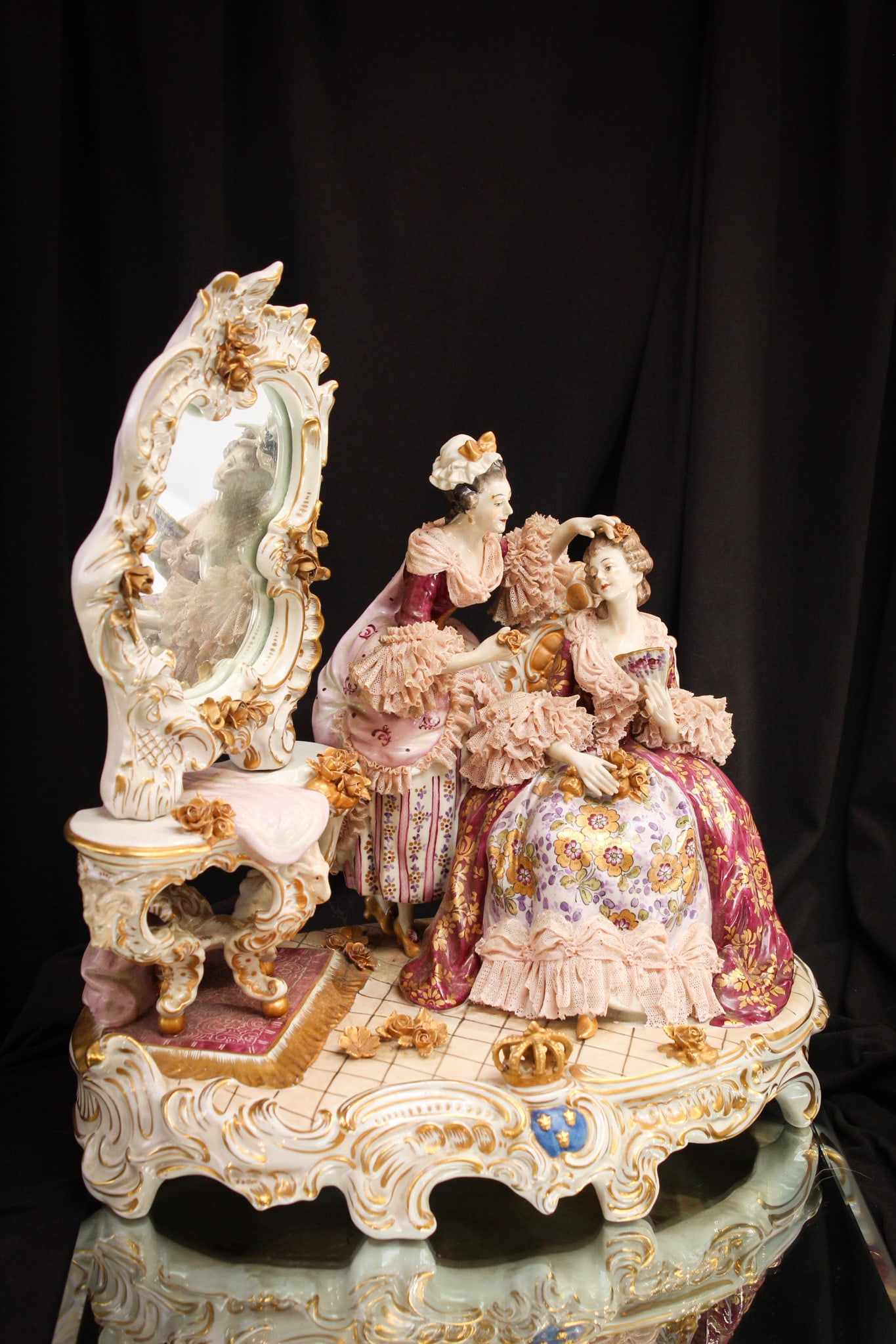 German 16" Porcelain Figural Grouping Statue: Grand German porcelain figural grouping featuring a lady getting ready and her mistress attending to her. Piece features full dressing vanity with mirror. Measures 14" tall, 16" wide.