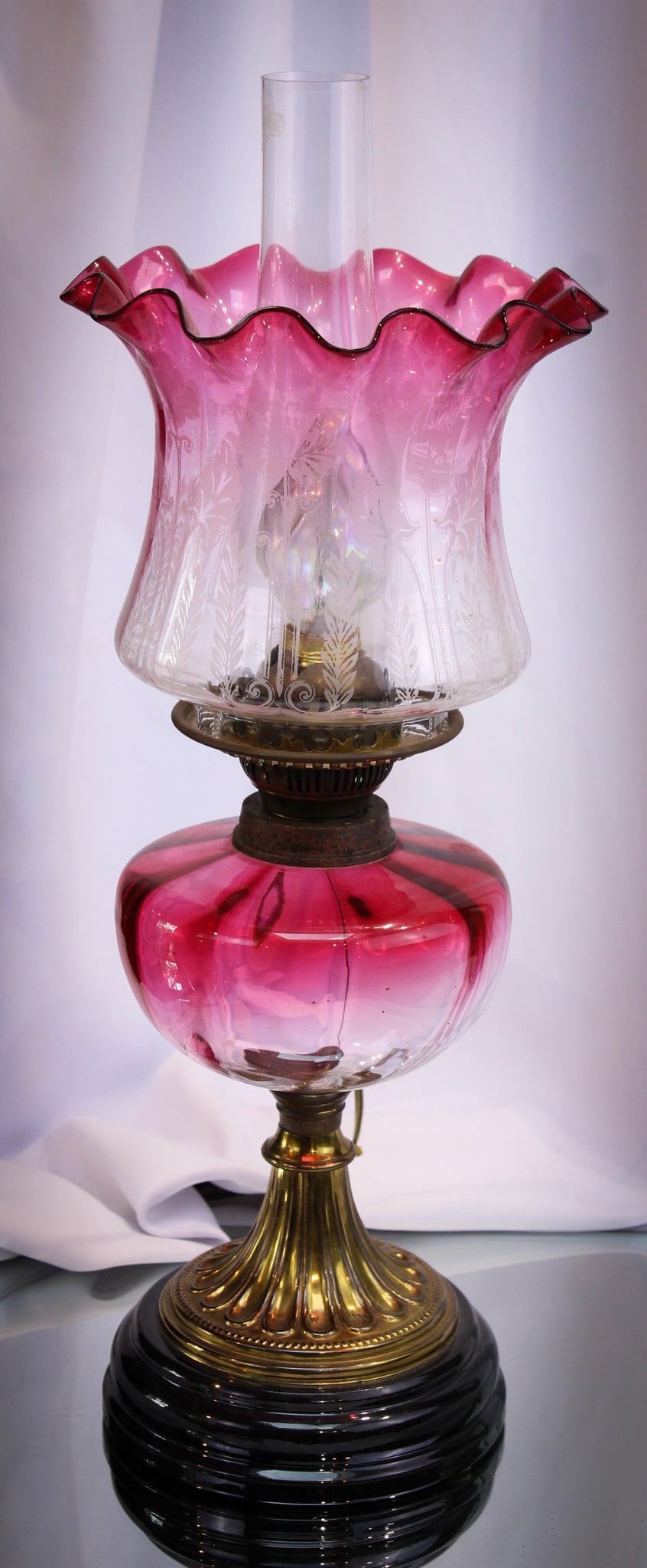 Victorian Cranberry English Oil Lamp: Wonderful cranberry Victorian English stand oil lamp complete with cranberry etched shade. Wonderful lamp with great well matched coloring. Burner has been electrified as can be seen. Fine example.