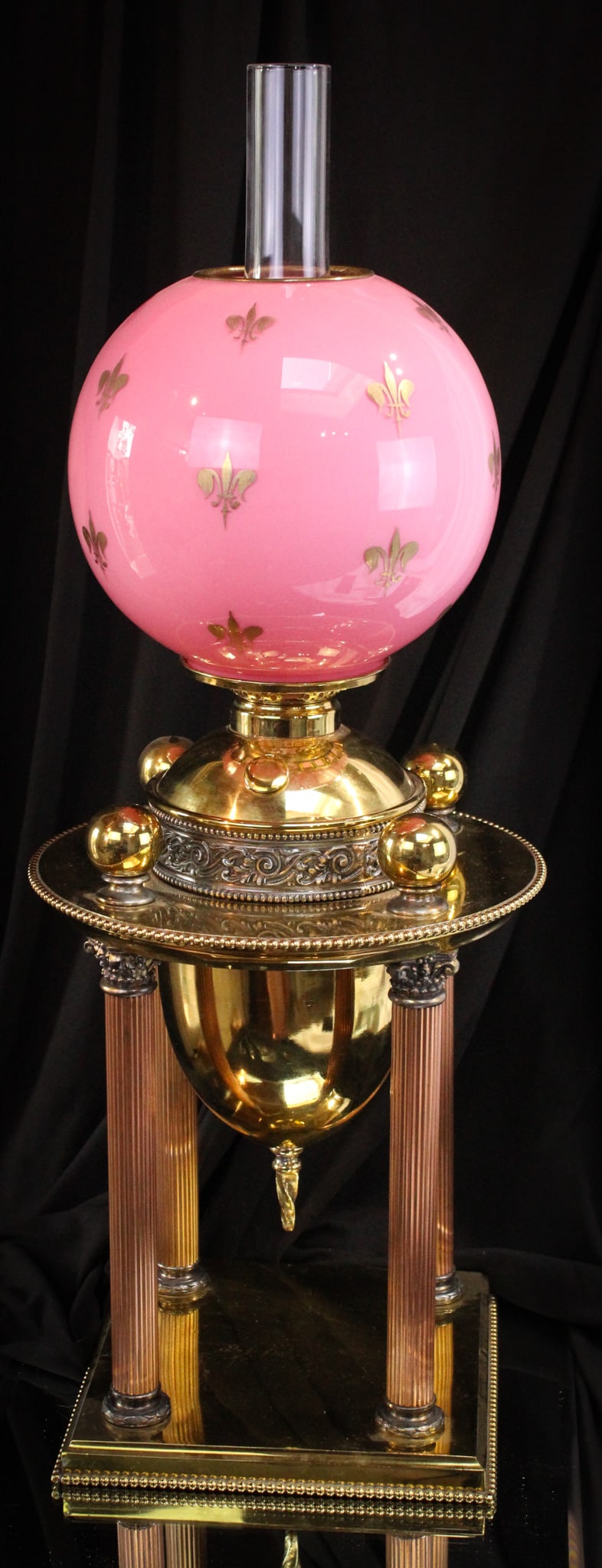 Victorian Brass Columnar Oil lamp Fleur de Lis Glass Shade: Amazing Victorian brass columnar base oil lamp completed by a pink cased Fleur Des Lis gilt decorated shade. Lamp complete measures 25" tall, 9 1/2" wide.