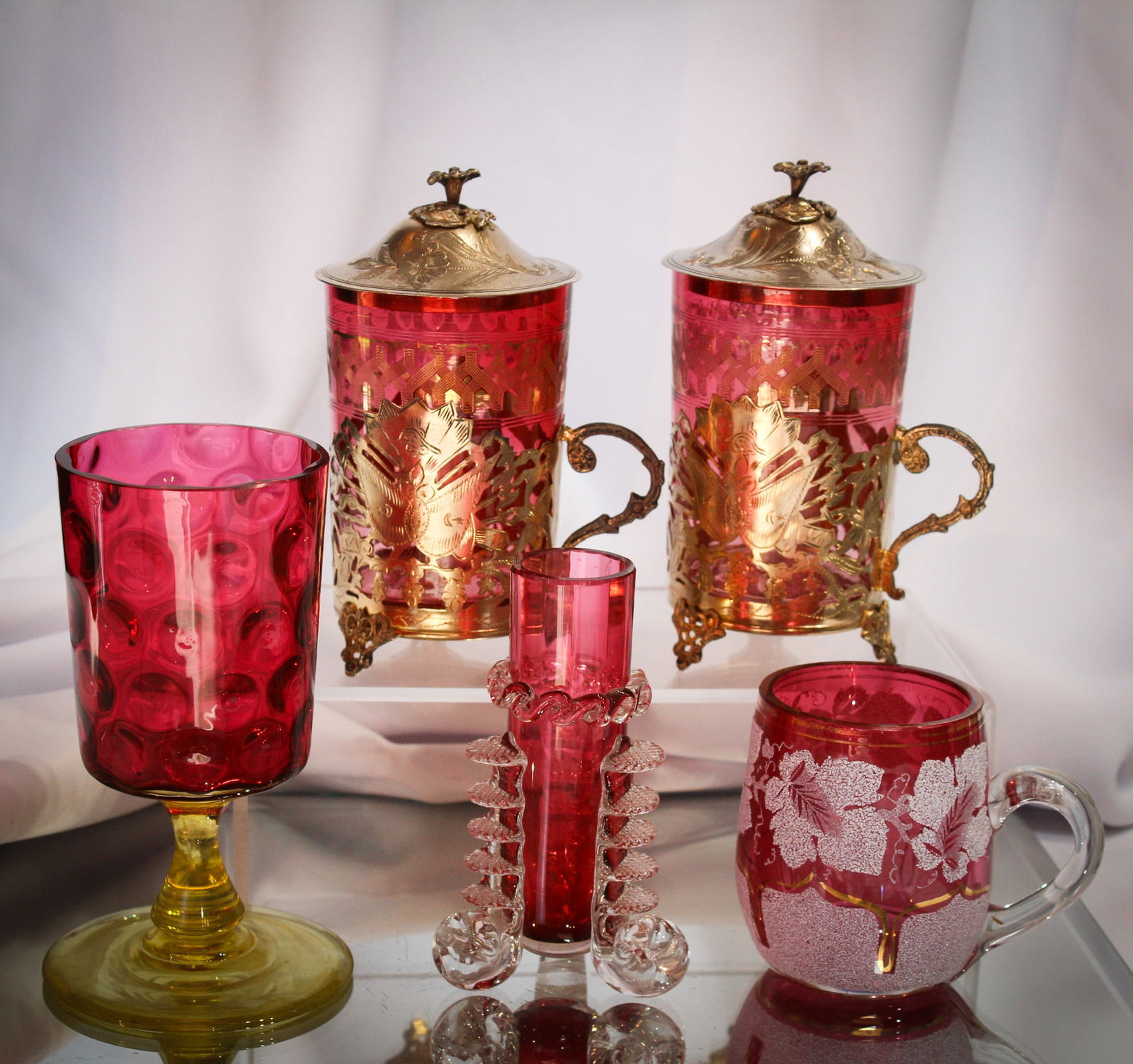 5 pc Lot Cranberry Glass Vaseline Silverplate & More: Great selections in this lot of five wonderful cranberry related items. Lot is comprised by two cranberry with gilt engraving Victorian lidded tea cups with silverplate mountings, a cranberry and vase