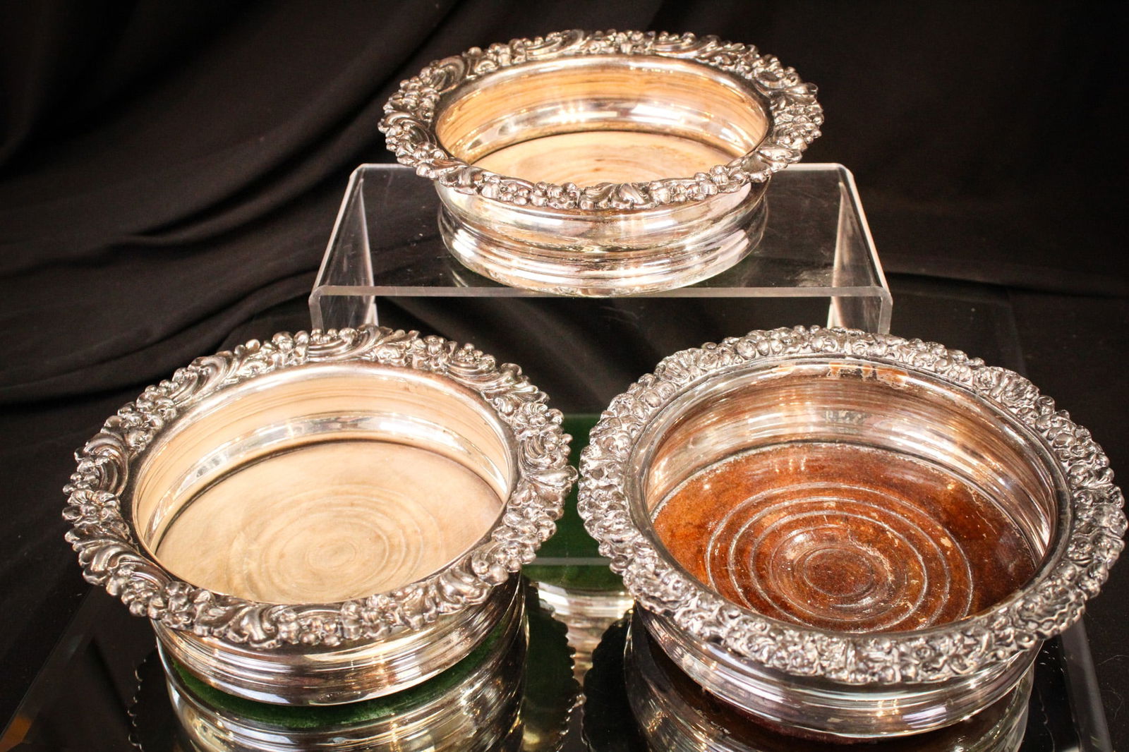 3 pc Lot English Silverplate & Wood Wine Bottle Coasters: Three fine examples of English silverplate in the form of wine bottle coasters complete with wood inset bases. Each measures 2" tall, 6" in diameter.