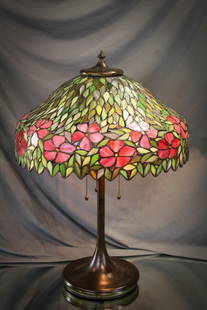 Unique Art Glass Co. Leaded Glass Table Lamp: Gorgeous Unique Art Glass Co. leaded table lamp. Lamp base in beautiful patina. Shade with dark green leaves and brilliant pink flowers around the border. Lamp measures 24" tall, 16 1/2" diameter.