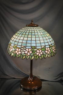 Unique Art Glass Co. Leaded Glass Table Lamp: We love the color of aqua blue the body of the shade of this Unique Art Glass Co. lamp has. White blossoms encircle the border of the shade. Nice patina to the base. Lamp measures 23" tall, 16 1/4" di