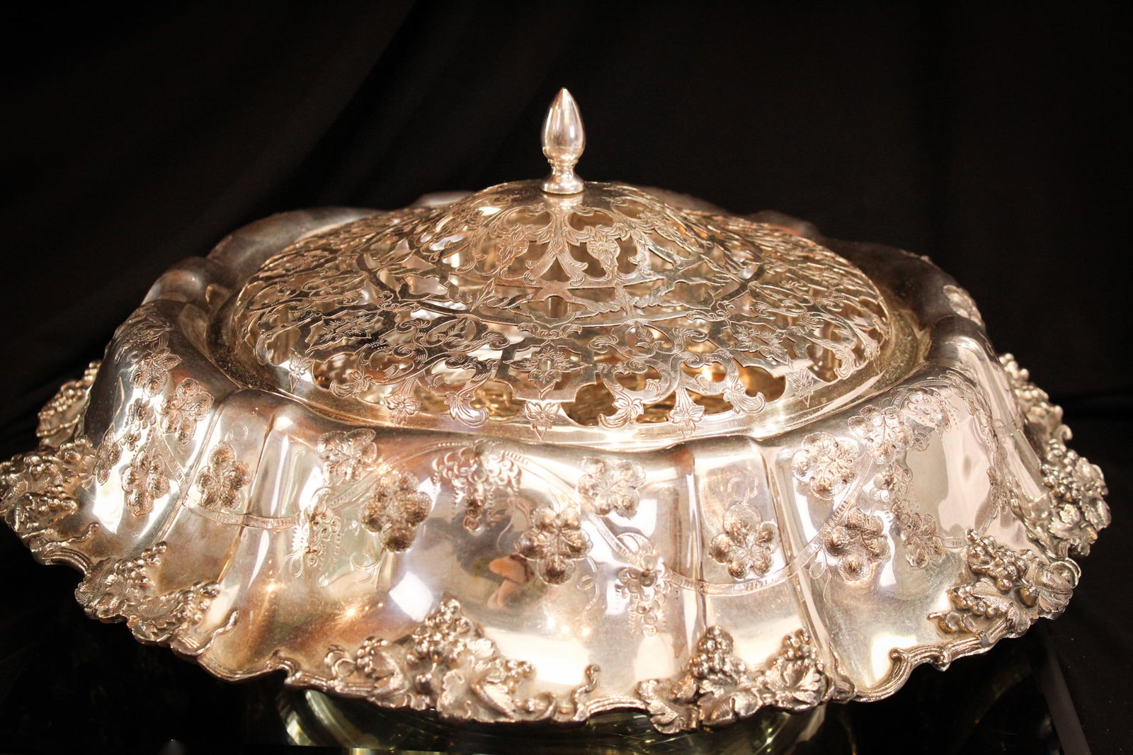 English Silverplate Hallmarked Flower Arranger Centerpiece: English hallmarked silverplate ornate flower arranger centerpiece. Piece ornate detailed with grape motif. Measures 7" tall, 15" in diameter.