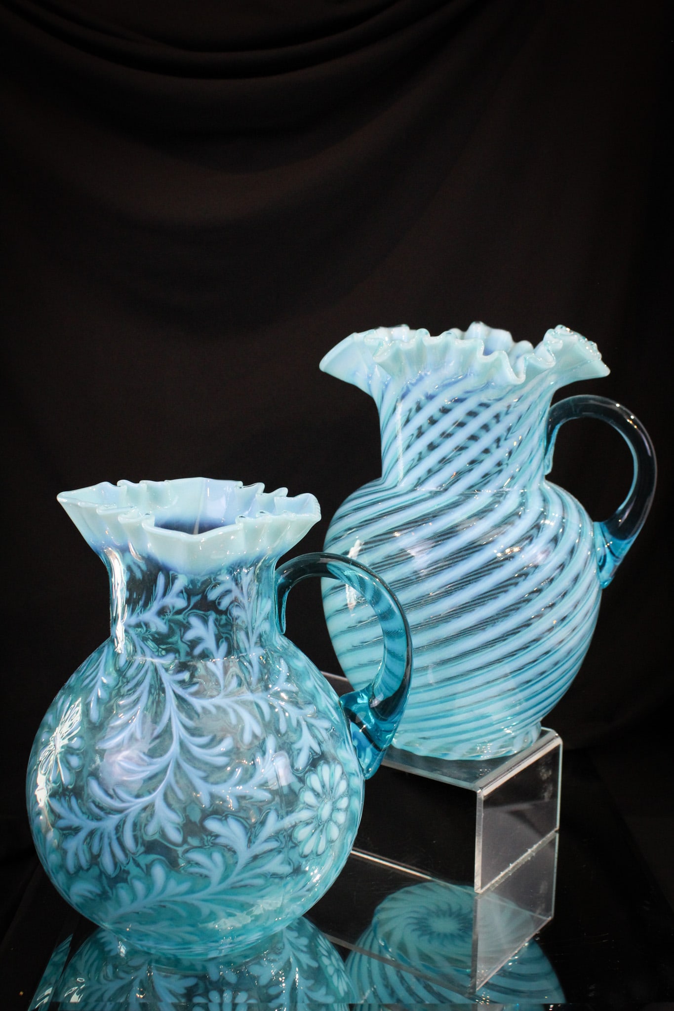2 pc Lot Blue Opalescent Victorian Water Pitchers: Two fine and unique examples of Victorian opalescent water pitcher. The first a blue opal Fenton Spiral Optic. The second a blue opal Daisy & Fern Pattern Northwood example. Tallest measures 9 3/4".