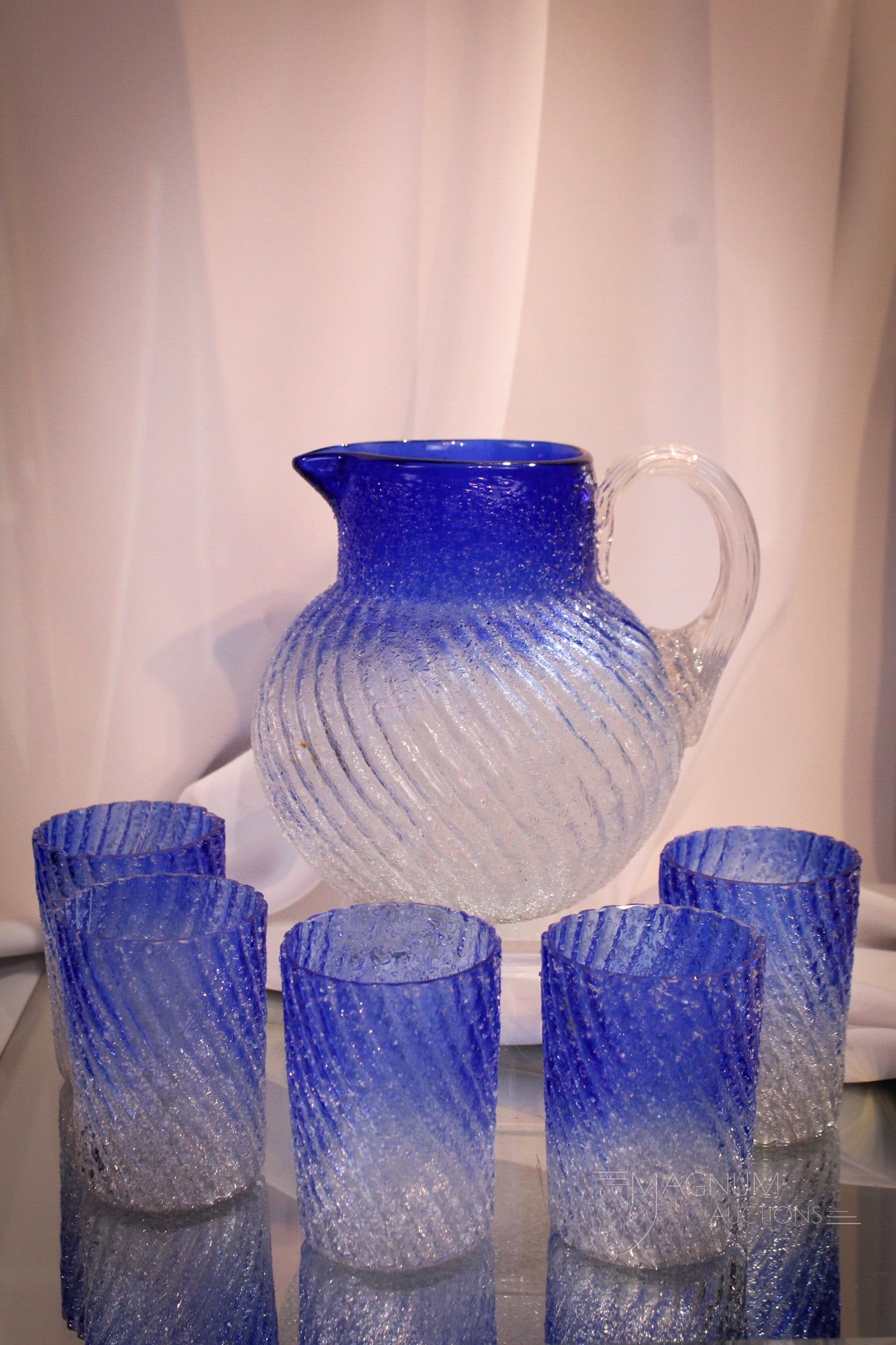 6 pc Victorian Cobalt Bluerina Overshot Glass Water Set: Striking and vivid cobalt blue Victorian overshot glass six piece water set. Set is a beautiful blue gradiated glass to clear. Enbossed swirl pattern. Tallest measures 6 1/2".