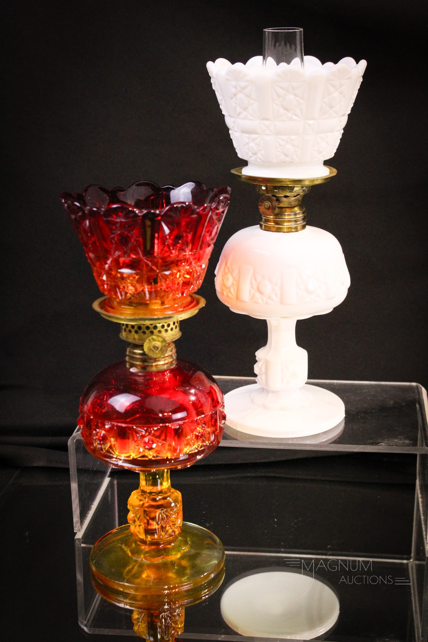 2 pc Lot L.G. Wright Miniature Oil Lamps: Two piece lot of L. G. Wright miniature oil lamps in the Stars & Bars pattern. One in amberina, one in milk glass. Each measures 8 1/2" tall.