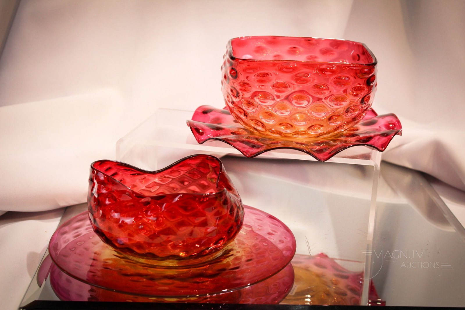 2 pc Lot Victorian Amberina Finger Bowls & Underplates: Two fine examples of Victorian amberina finger bowls with matching underplates. One in hobnail pattern, one in diamond quilt. Each with super coloring. Largest measures 2 3/4" tall, 7" in diameter.